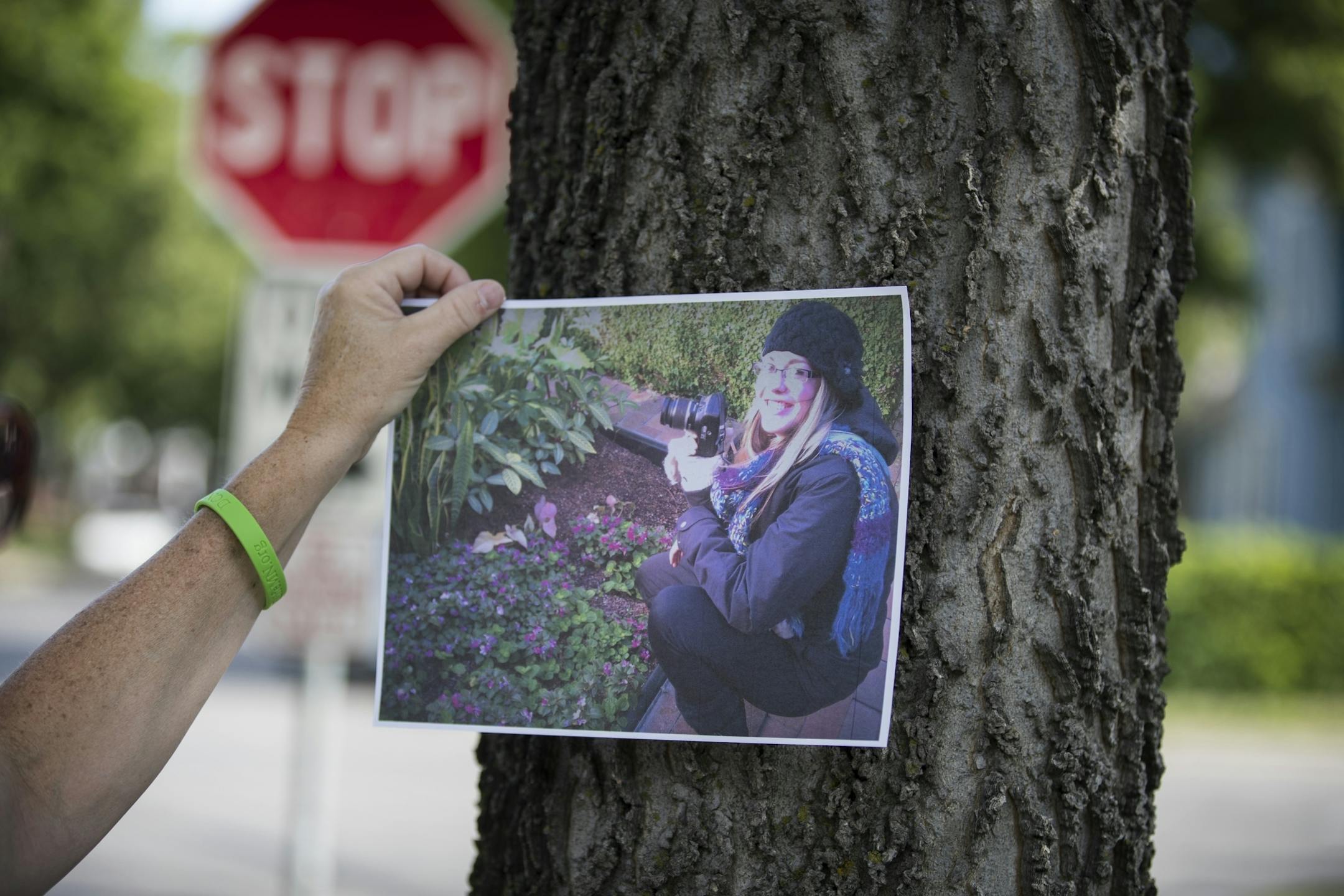 Jessica Hanson's mother Natalie Hanson tapes a photo of Jessica to a tree near where she was killed in Minneapolis.