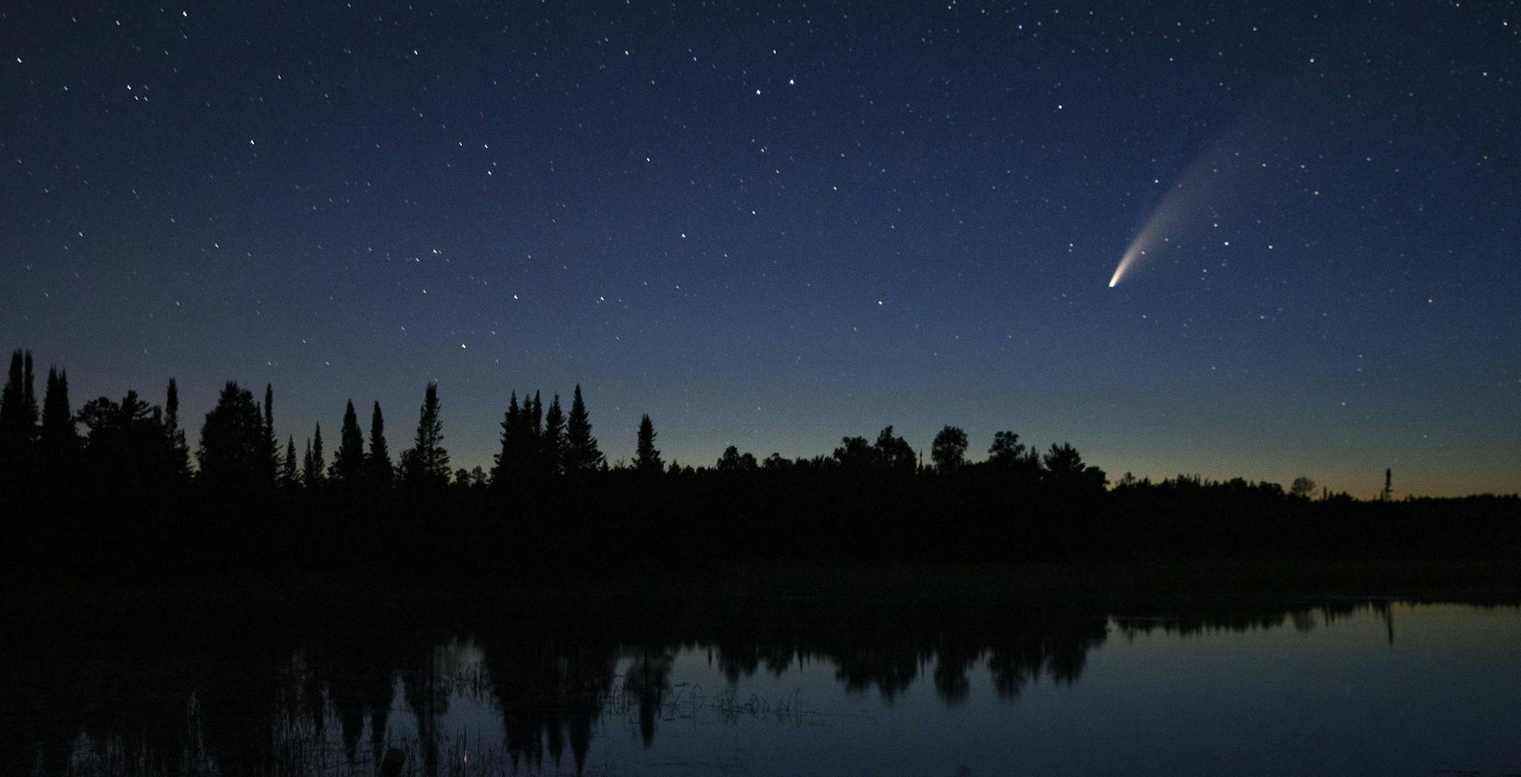Comet Neowise streaks across the night sky over Wolf Lake in Brimson, Minn., Tuesday night, July 14, 2020. Comet C/2020 F3 Neowise is a bright comet that only passes close enough for viewing on Earth once every 6,800 years or so. The comet streaked across the sky over Wolf Lake in Brimson, on July 14, between 10 and 11 p.m. (Alex Kormann/Star Tribune via AP)
