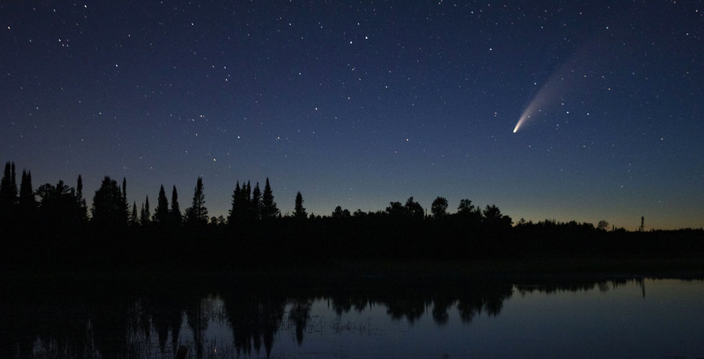 Comet Neowise streaks across the night sky over Wolf Lake in Brimson, Minn., Tuesday night, July 14, 2020. Comet C/2020 F3 Neowise is a bright comet that only passes close enough for viewing on Earth once every 6,800 years or so. The comet streaked across the sky over Wolf Lake in Brimson, on July 14, between 10 and 11 p.m. (Alex Kormann/Star Tribune via AP)