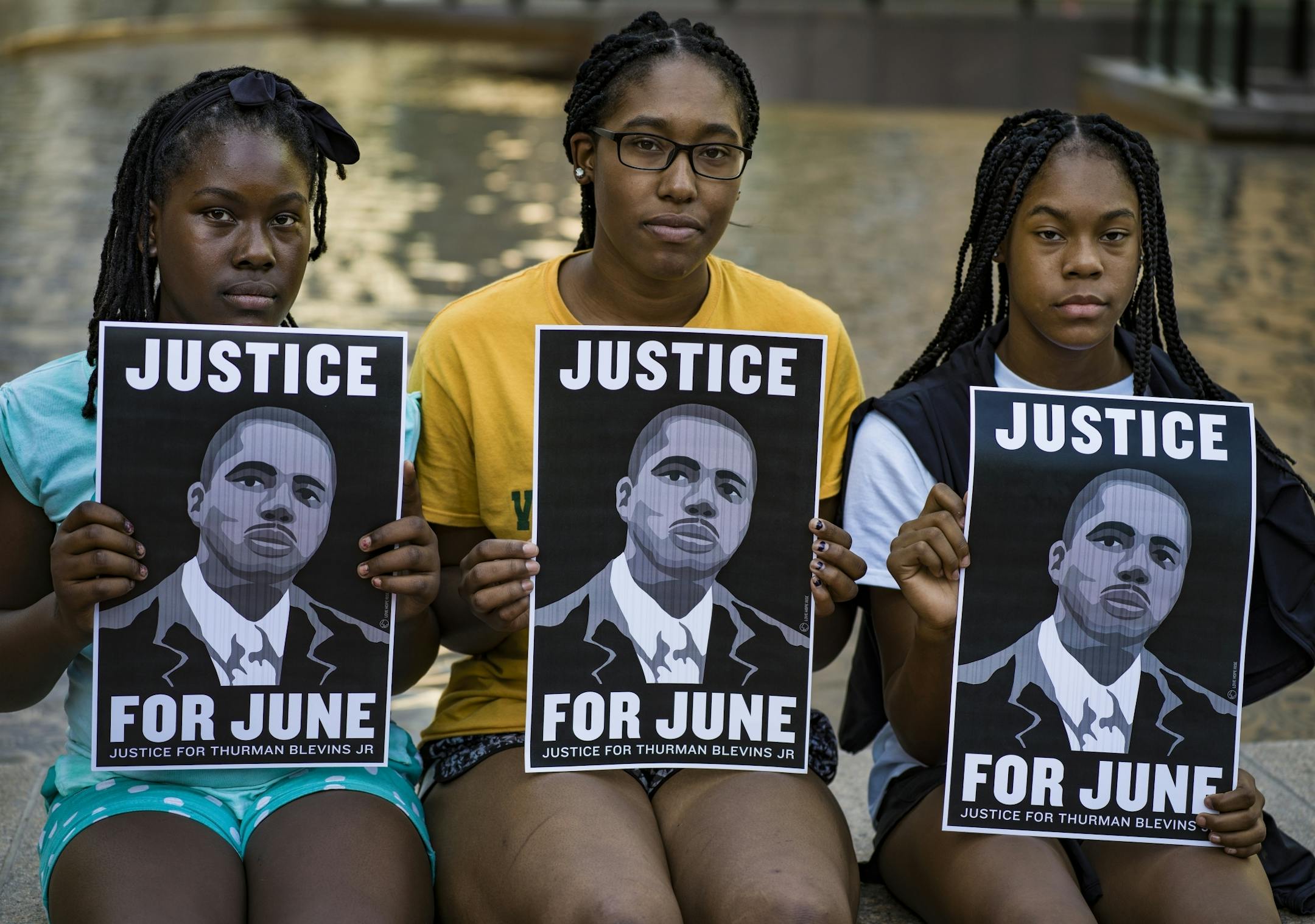 L to R: The Fields sisters Imana,10, JoQuyse,16, and Daima,13, all held posters to express theirs reason for being there at the Hennepin Government Center Plaza.