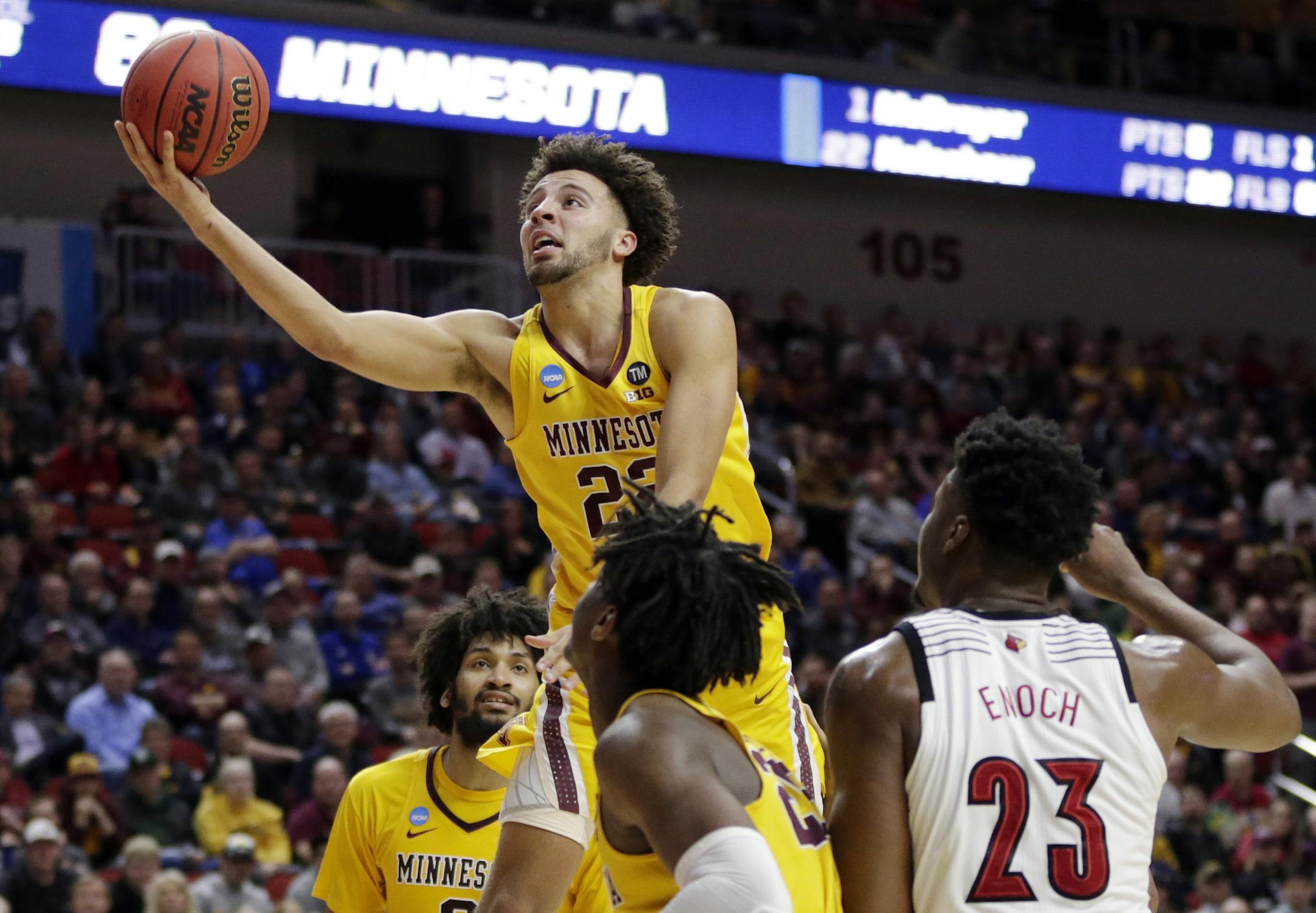 Minnesota's Gabe Kalscheur (22) goes for a layup as Louisville's Steven Enoch (23) watches during the second half of a first round men's college basketball game in the NCAA Tournament in Des Moines, Iowa, Thursday, March 21, 2019. (AP Photo/Nati Harnik)