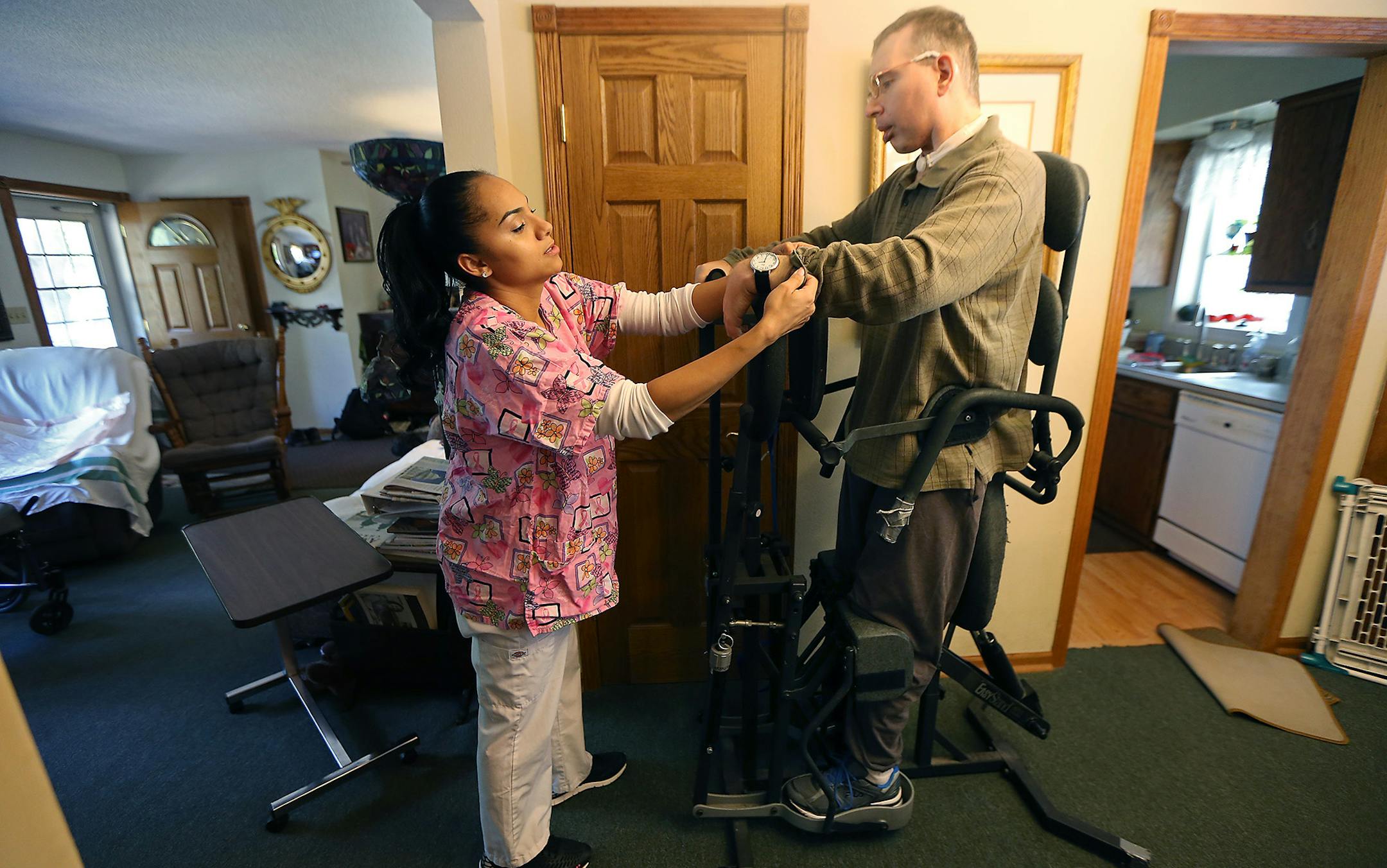 Jasmine Laducer-Kitto, a home care aide, helped her client, Scott Semo, with physical therapy, Thursday, September 29, 2016 in Roseville, MN. Jasmine has been Scott's personal care assistant for 11 years, but says the low pay has forced her to look for other jobs. Because of the shortage of home care workers, Jasmine often has to work two or three consecutive shifts -- making it difficult to be at home with her own kids. ] (ELIZABETH FLORES/STAR TRIBUNE) ELIZABETH FLORES &#x2022; eflores@startri