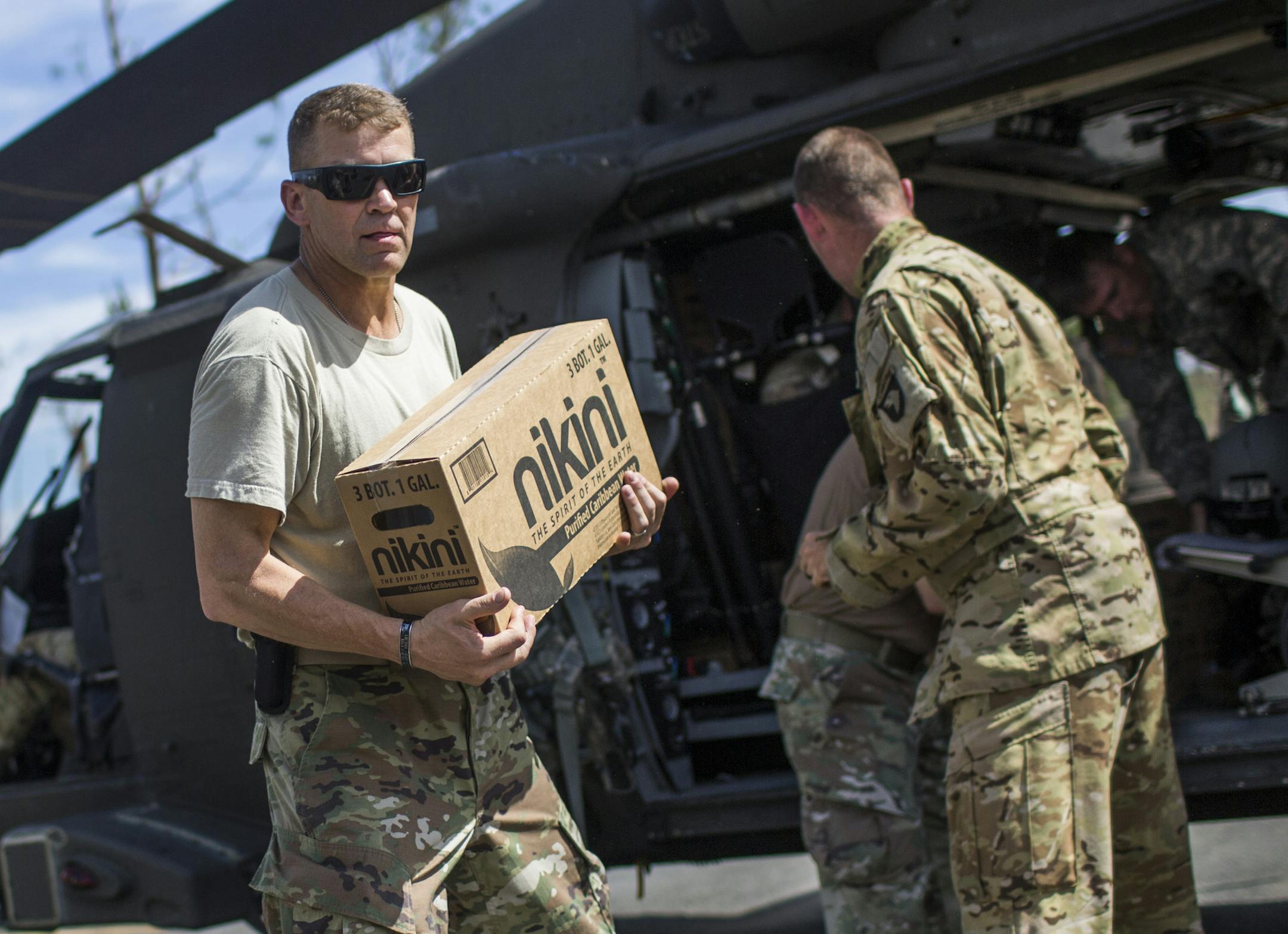 Lt. Gen. Jeffrey Buchanan, center, who is heading the military effort in Puerto Rico, participates in the distribution of relief supplies in Cidra, a small town an hour south of San Juan, Oct. 13, 2017. Buchanan said that conditions were only somewhat improved since he arrived two weeks ago. “It’s still complete devastation across the island,” he said. “It’s going to take a long time to fix.” (Dennis M. Rivera Pichardo/The New York Times)