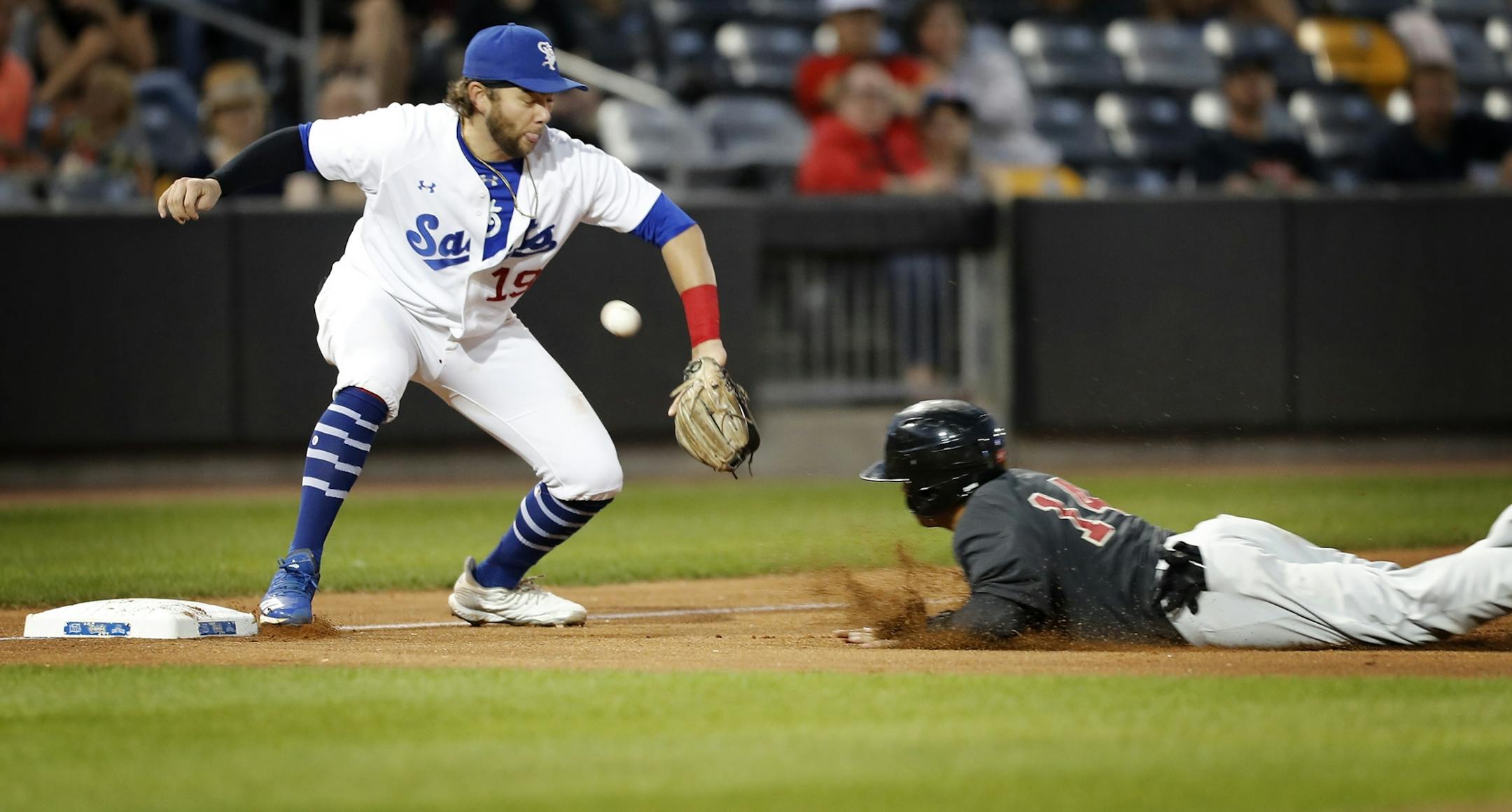 Saint Paul Saints third baseman Dante Bichette Jr. loses the ball and Kansas City's Anthony Phillips is safe at third base.
