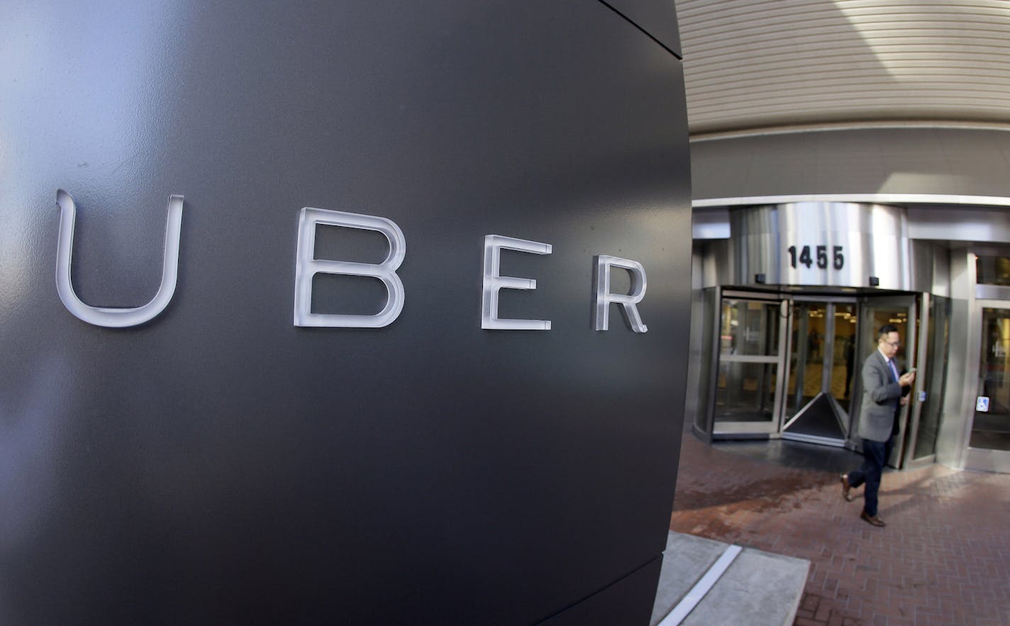 FILE - In this Dec. 16, 2015, file photo, a man leaves the headquarters of Uber in San Francisco. Instead of listing their shares on a stock exchange, more businesses are going private or never going public in the first place. Uber makes it simple for customers to hail a car, but investors can't easily buy a piece of the privately held company, which is valued at more than $60 billion. (AP Photo/Eric Risberg, File)