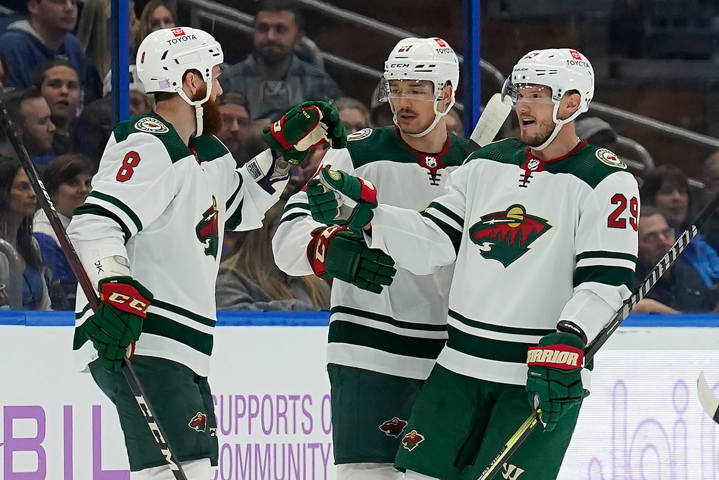 Wild right wing Brandon Duhaime (21) celebrates his goal against the Tampa Bay Lightning with defensemen Jordie Benn (8) and Dmitry Kulikov (29).