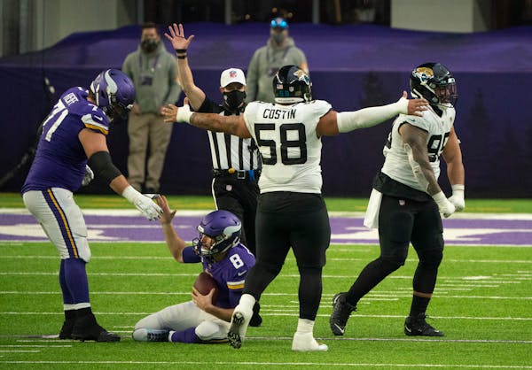 Minnesota Vikings quarterback Kirk Cousins (8) was helped up by Minnesota Vikings offensive tackle Riley Reiff (71) after he was sacked in the fourth 