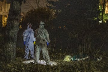 Students in protective suits evaluated a mock crime scene at Hamline University, where assistant professor Jamie Spaulding calls his students out in t