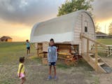The author’s granddaughters check into a covered wagon available for an overnight stay at the Ingalls Homestead in De Smet, S.D.