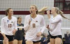 The University of Minnesota's Molly Lohman (13), Samantha Seliger-Swenson (11) and Paige Tapp (4) celebrate a point against the University of Missouri