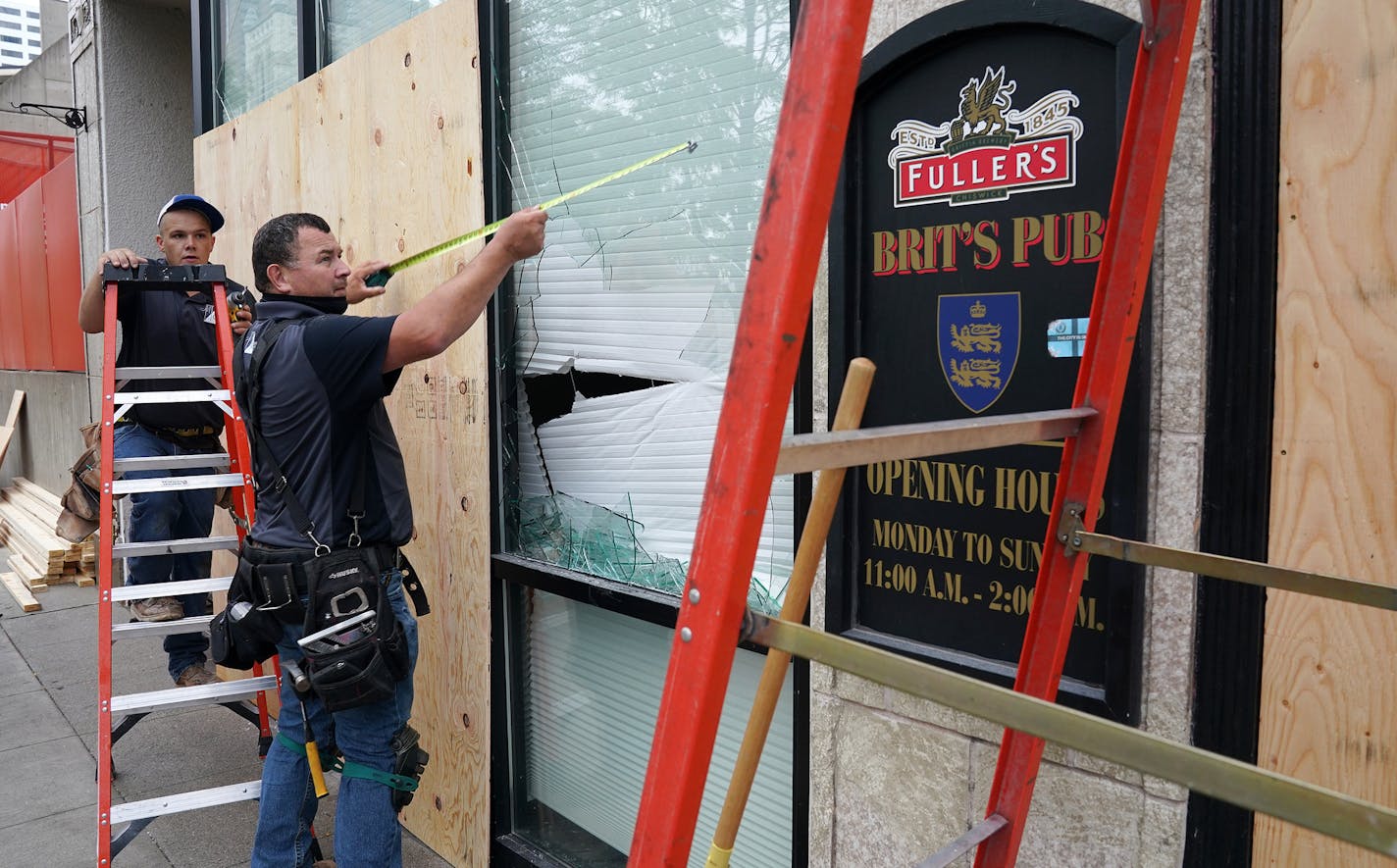 Seth Johnson, a supervisor with MP Johnson Construction, measured a window for boarding up at Brit's Pub on Nicollet Mall where several businesses were damaged by a group of looters Wednesday night after the suicide of a homicide suspect on the Mall ignited rioting. ] ANTHONY SOUFFLE • anthony.souffle@startribune.com Community members and business owners cleaned up the damaged on Nicollet Mall caused by a group of looters Wednesday night after the suicide of a homicide suspect on the Mall ignite