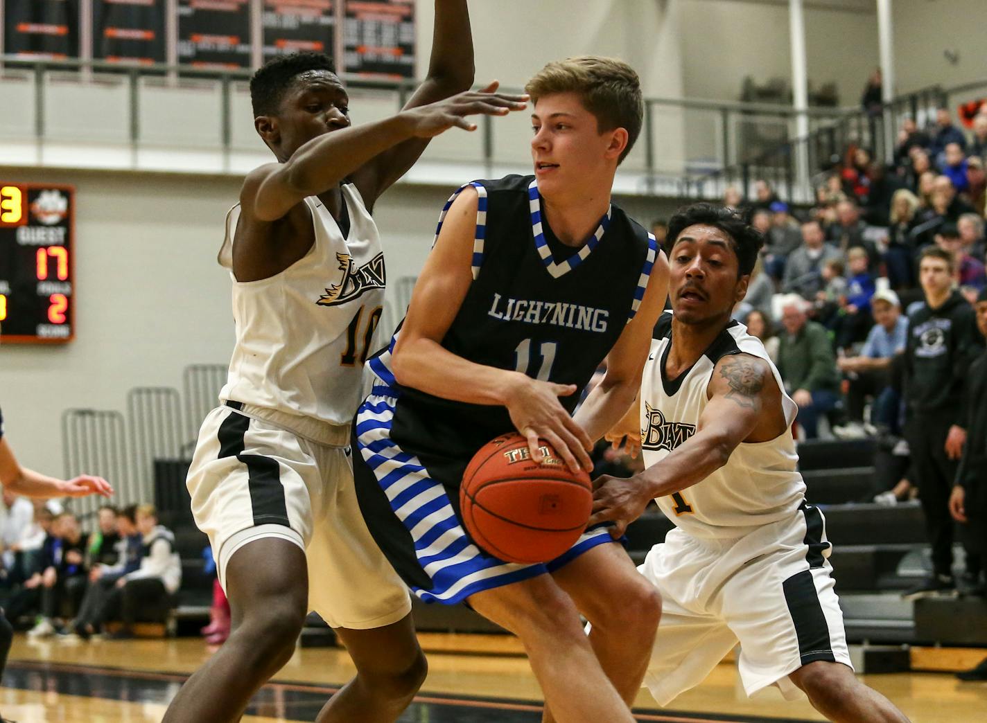 Jackson Purcell (11) is trapped in the corner by Cedric Ung (10) and Julian Quiroz-Hutchinson (1) forcing a jump ball. Eastview leads Burnsville at halftime by a score of 33-27 at Farmington High School. Photo by Cheryl Myers, SportsEngine