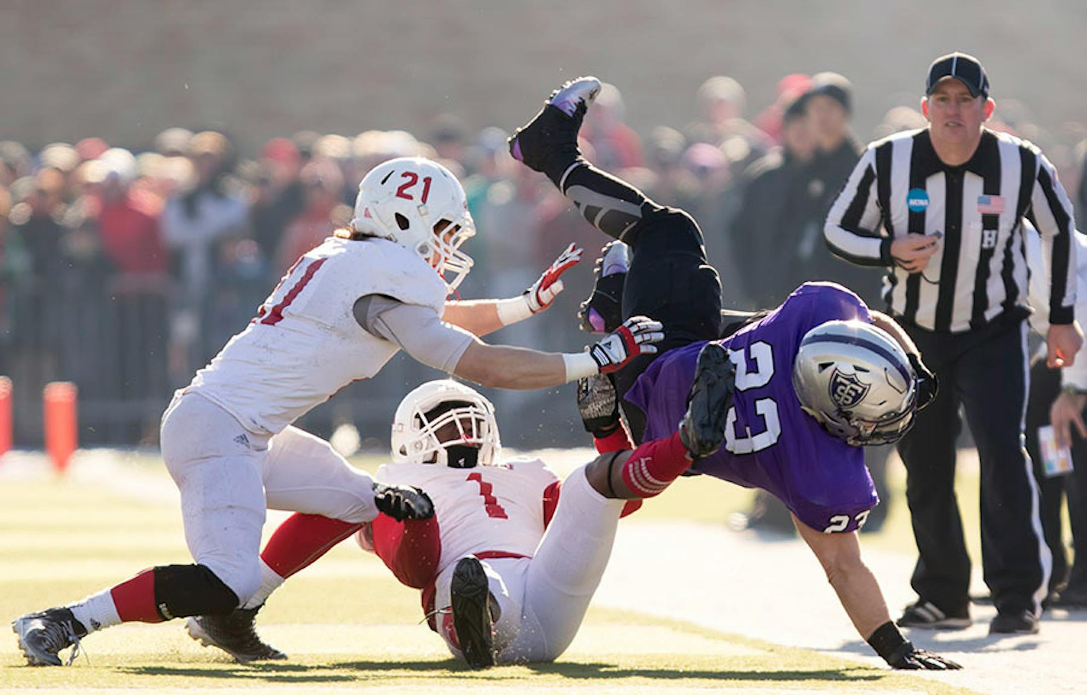 St. Thomas running back Jordan Roberts (23) is tackled by St. John's defensive back Jeremy Piper (1) and St. John's defensive back Lucas Glomb (21) as the University of St. Thomas Tommies hosted the St. John's University Jonnies on November 28, 2015.