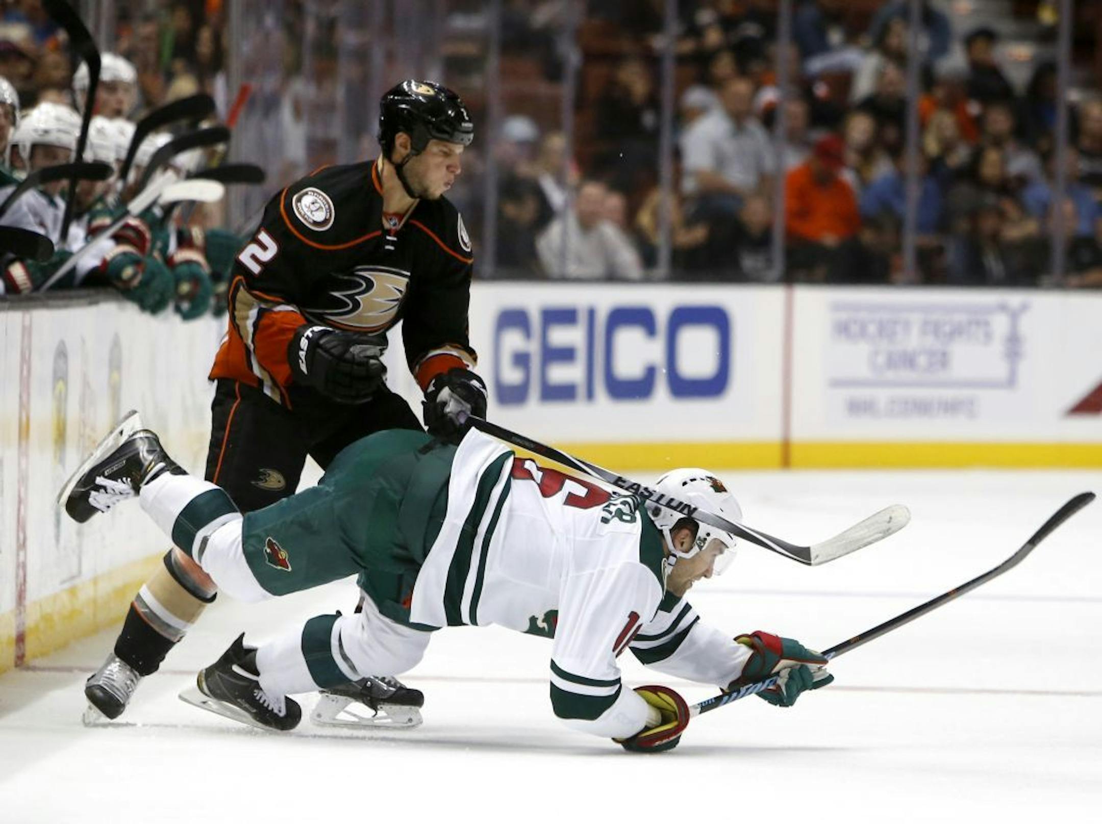 Minnesota Wild's Jason Zucker, bottom, hits the ice while battling Anaheim Ducks' Kevin Biekska in the second period of an NHL hockey game in Anaheim, Calif., Sunday, Oct.18, 2015.