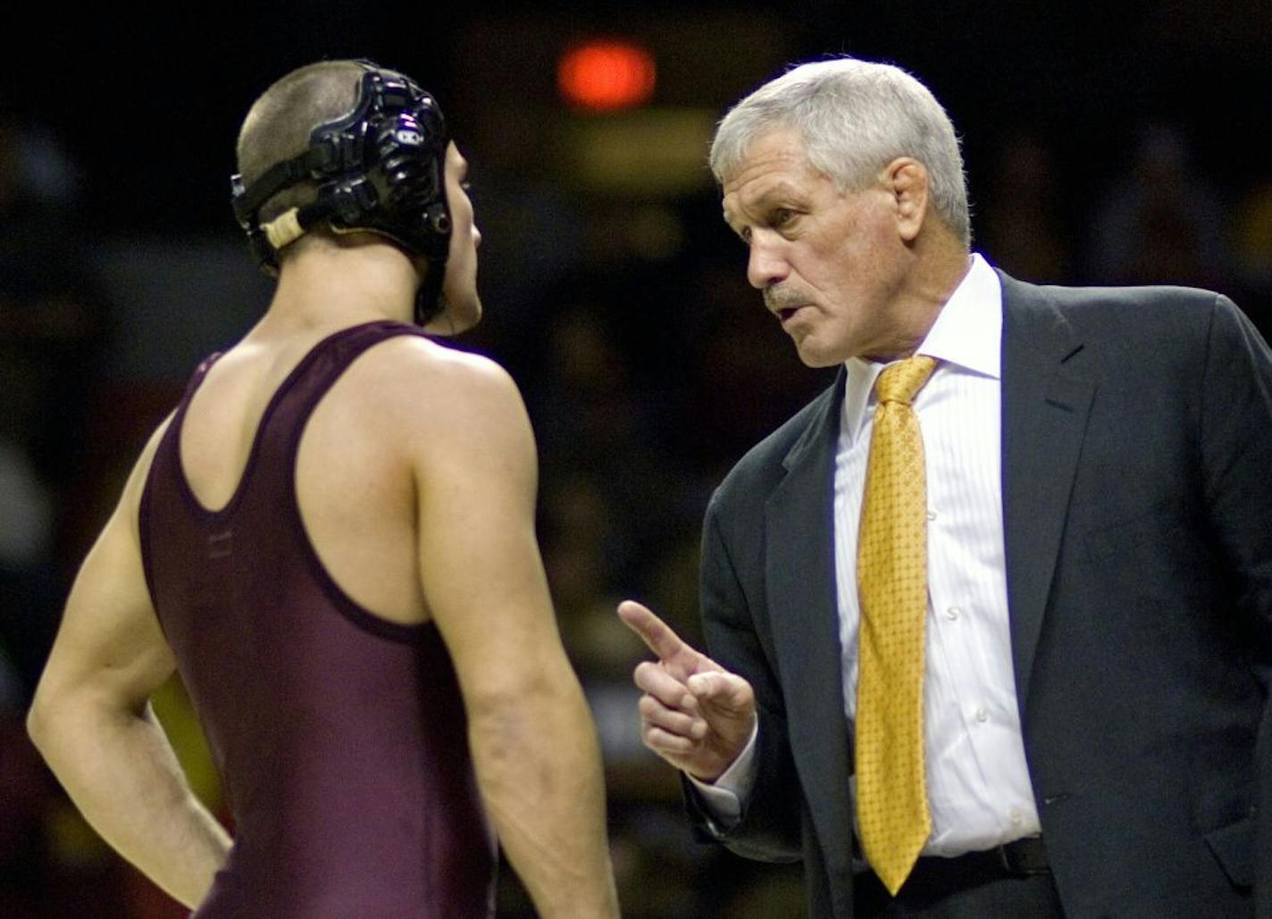 Gophers wrestling coach J Robinson talks with a U wrestler.