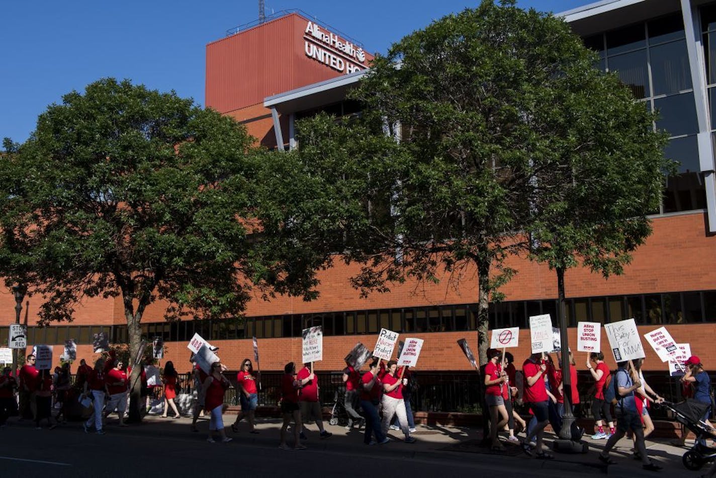 Picketers walk in front of United Hospital in St. Paul, Minn., Sunday, June 19. 2016. About 4,800 nurses at five Minneapolis-area hospitals, all operated by Allina Health, began a weeklong strike Sunday over a contract impasse.