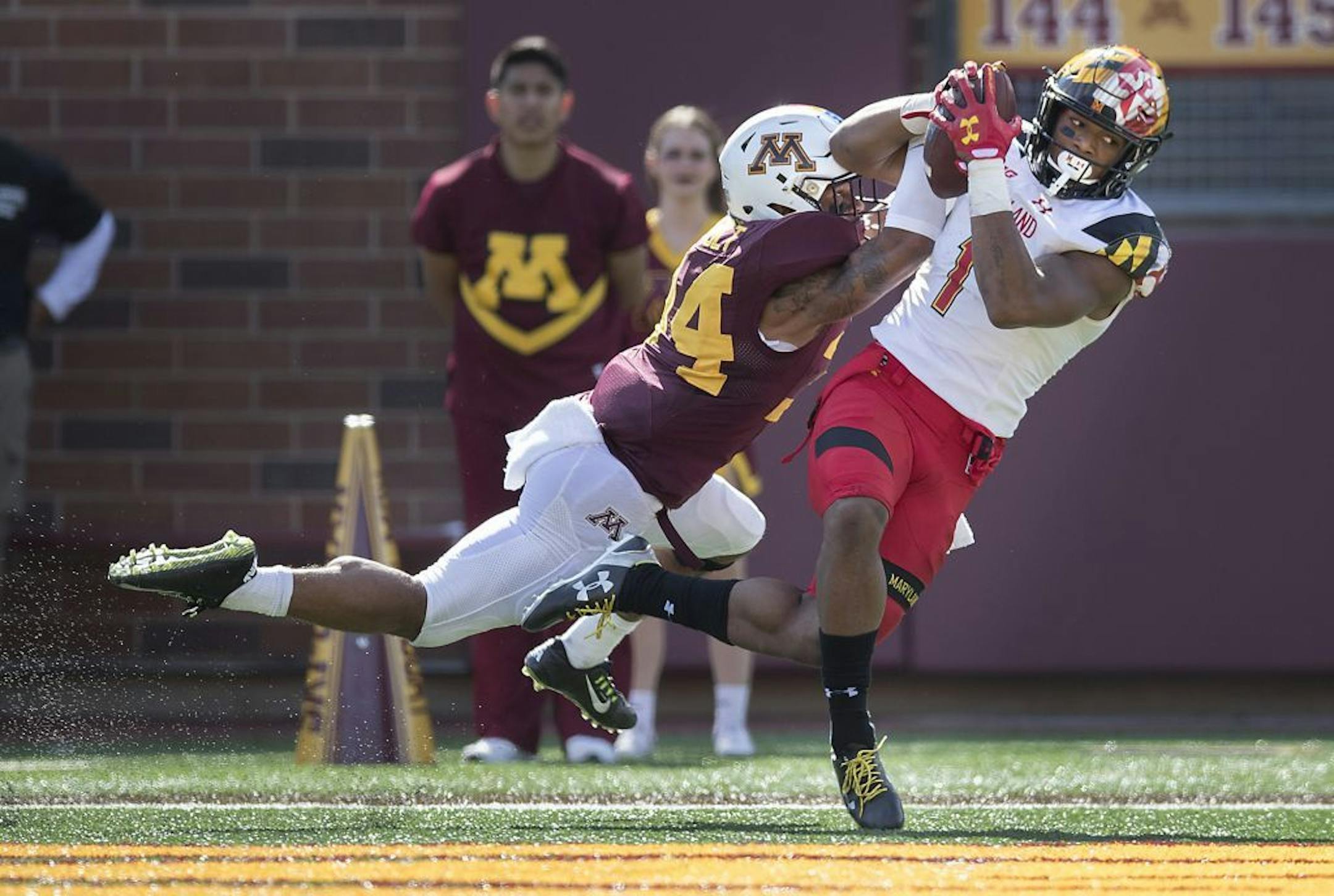 Maryland wide receiver D.J. Moore hauls in a touchdown pass despite the defensive efforts of Minnesota defensive back Antonio Shenault during the second quarter at TCF Bank Stadium on Saturday.