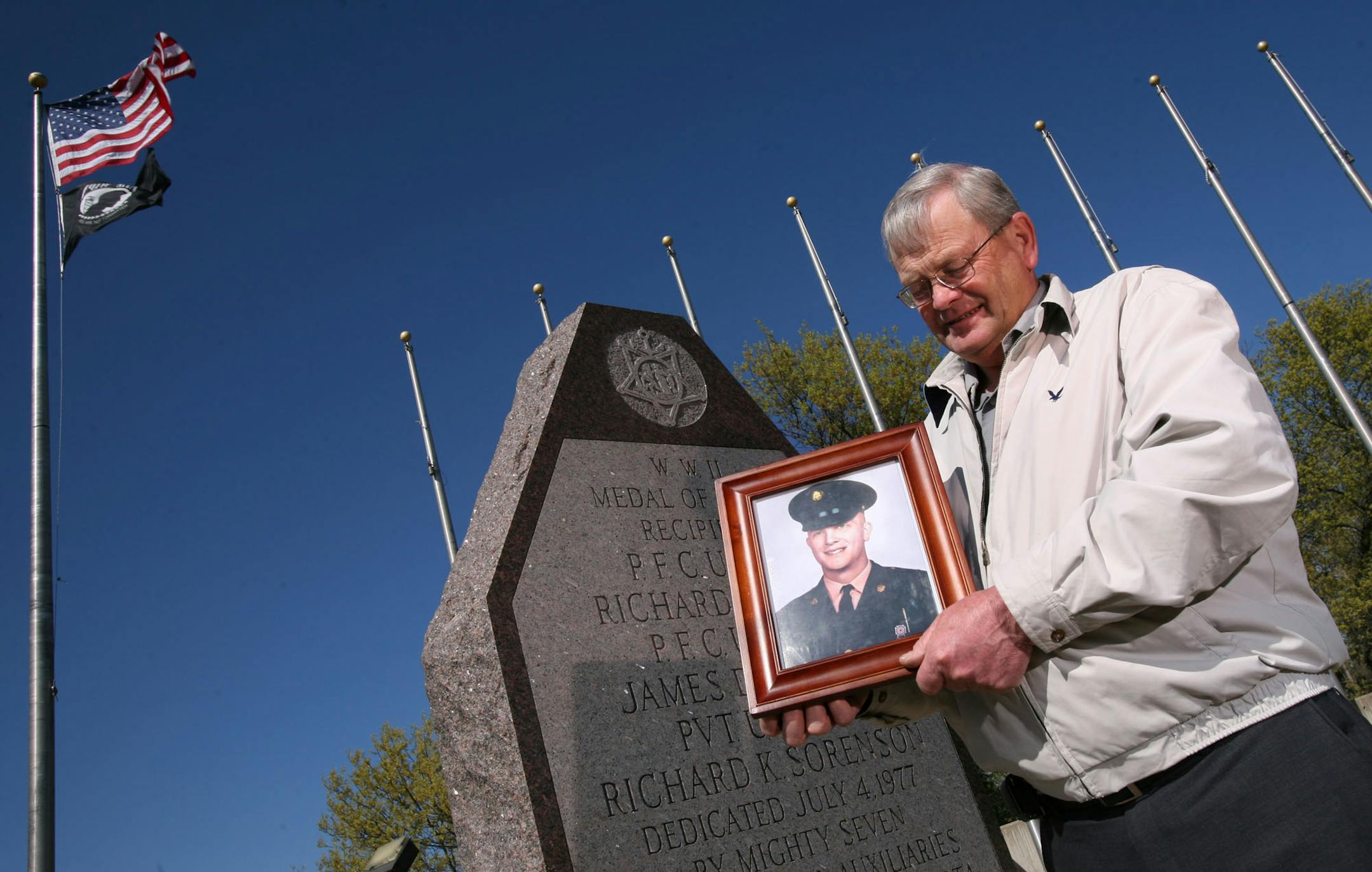 This Memorial Day, Anoka County Commissioner Dennis Berg will try to honor "the best friend I will ever have", a man Berg never met, but who sacrificed his life to save him during the Vietnam War. Berg holds a picture of this man, PFC Russell Louis Halley, at the veteran's memorial at Bunker Hills Regional Park recently.