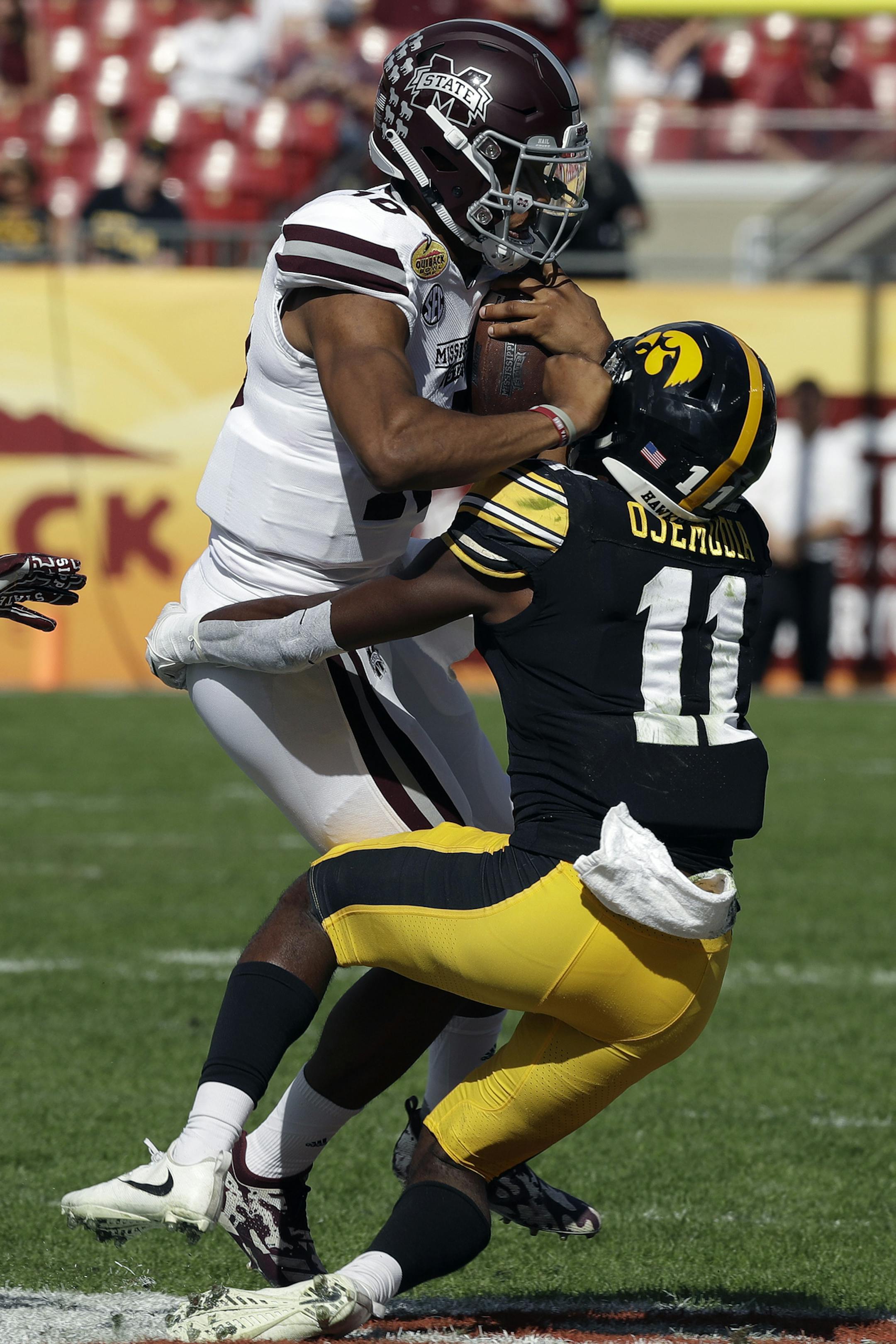 Mississippi State quarterback Keytaon Thompson (10) gets hit by Iowa defensive back Michael Ojemudia (11) on a run during the first half of the Outback Bowl NCAA college football game Tuesday, Jan. 1, 2019, in Tampa, Fla. (AP Photo/Chris O'Meara)