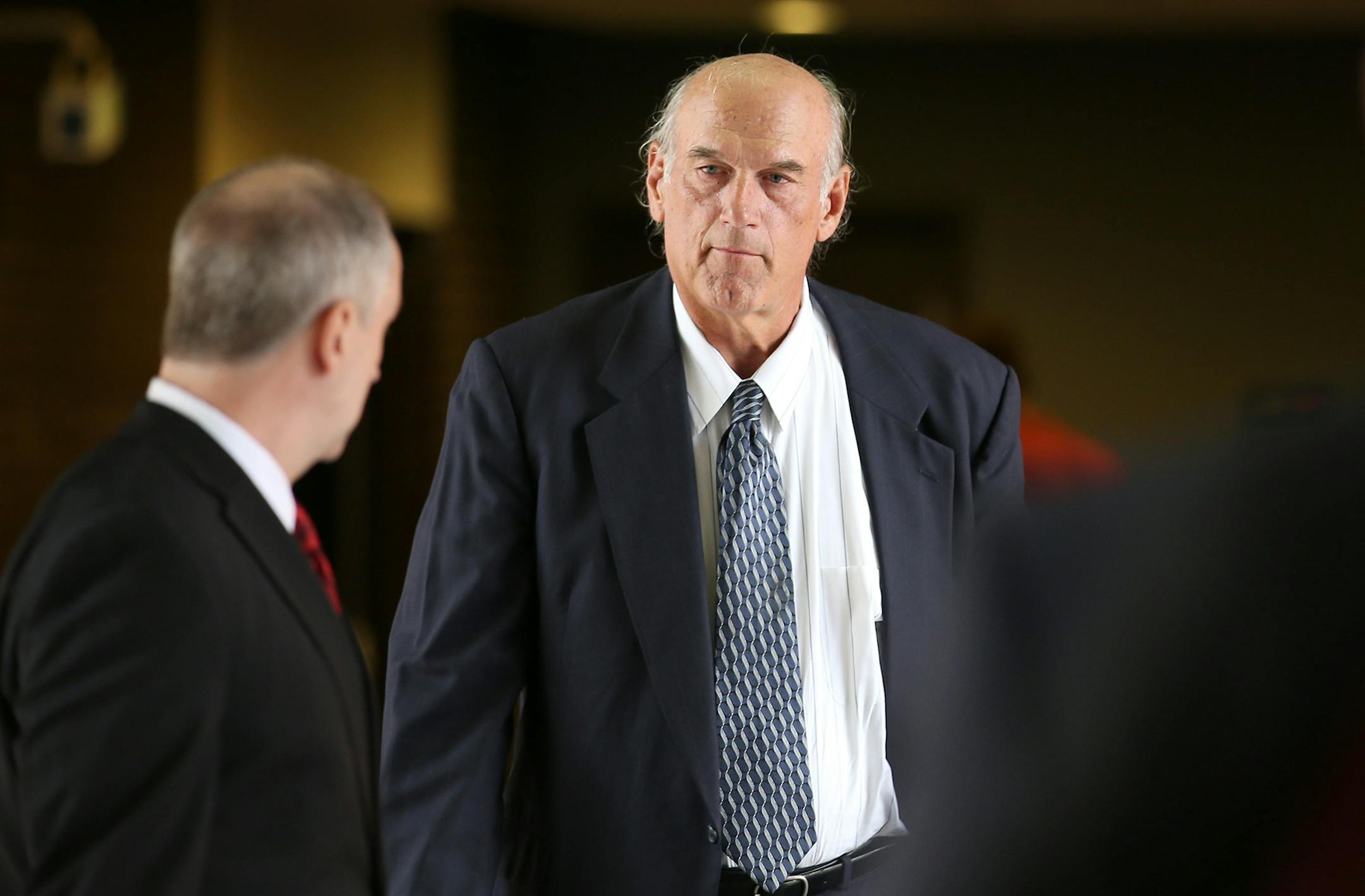 Former Minnesota Gov. Jesse Ventura, right, made his way back into Warren E. Burger Federal Building during the first day of jury selection in a defamation lawsuit, July 8, 2014.