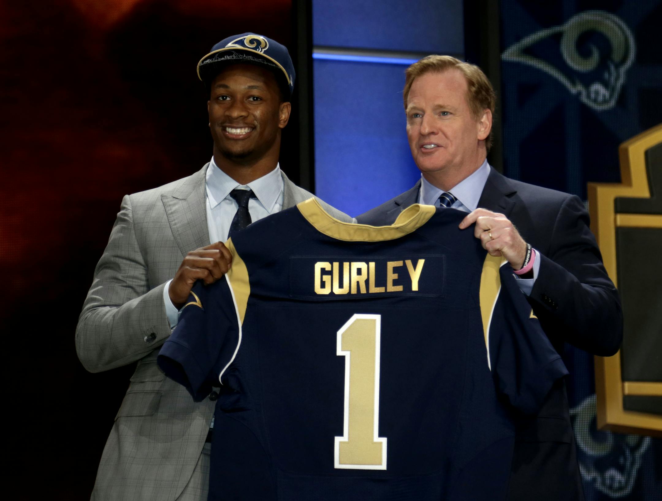 Todd Gurley stands on stage with NFL commissioner Roger Goodell, right, after being drafted tenth by the St. Louis Rams in the first round of the 2015 NFL Draft, Thursday, April 30, 2015, in Chicago. (Jeff Haynes/AP Images for Panini)