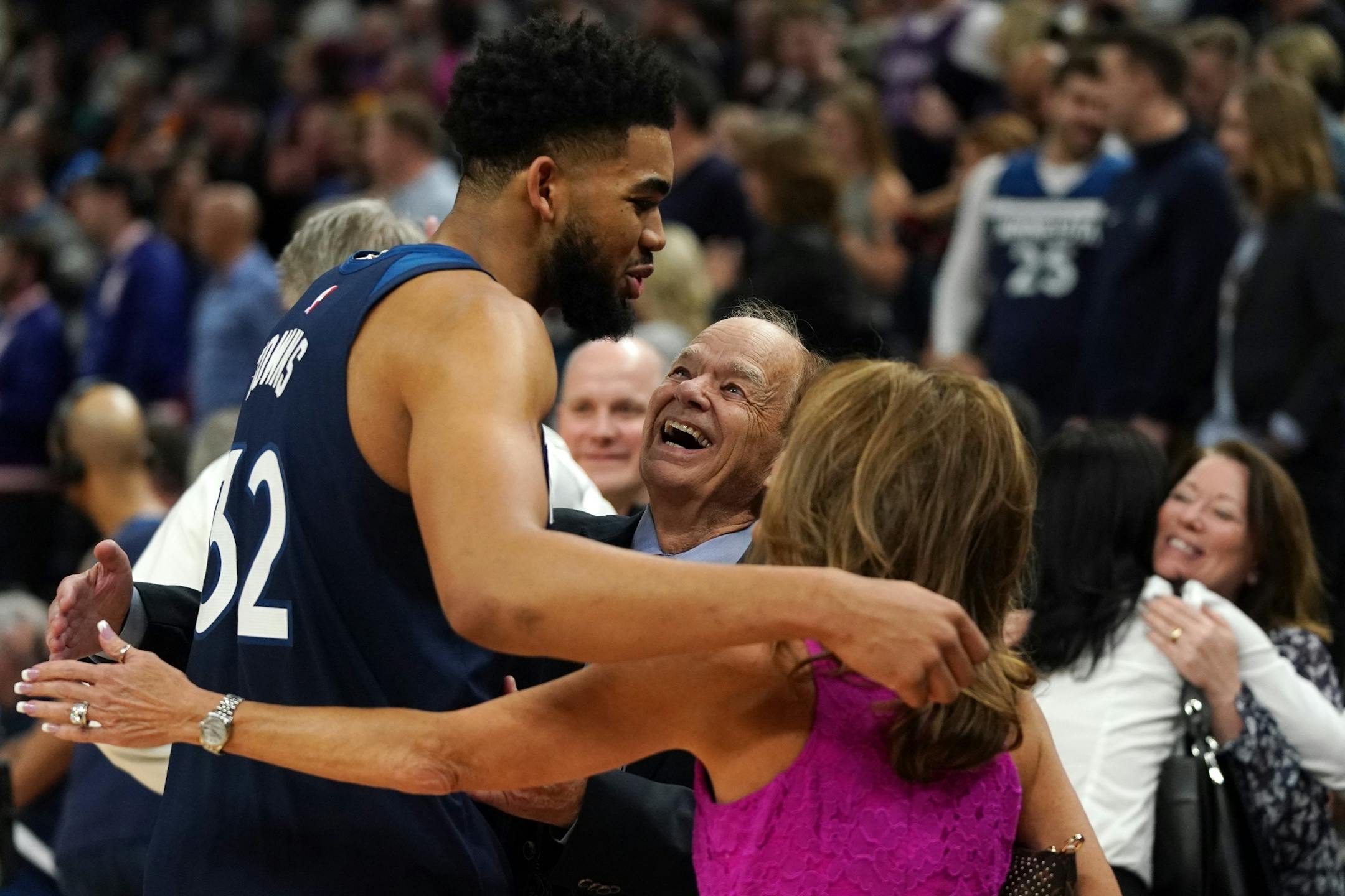 Minnesota Timberwolves center Karl-Anthony Towns (32) was congratulated by team owner Glen Taylor and his wife Becky after the win over the Golden State Warriors in overtime.