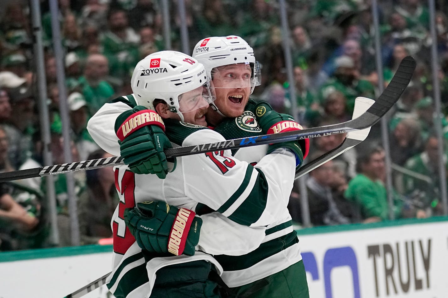 Minnesota Wild's Sam Steel (13) and Gustav Nyquist, right, celebrate a goal scored by Steel in the second period of Game 1 of an NHL hockey Stanley Cup first-round playoff series against the Dallas Stars, Monday, April 17, 2023, in Dallas. (AP Photo/Tony Gutierrez) ORG XMIT: TXTG107