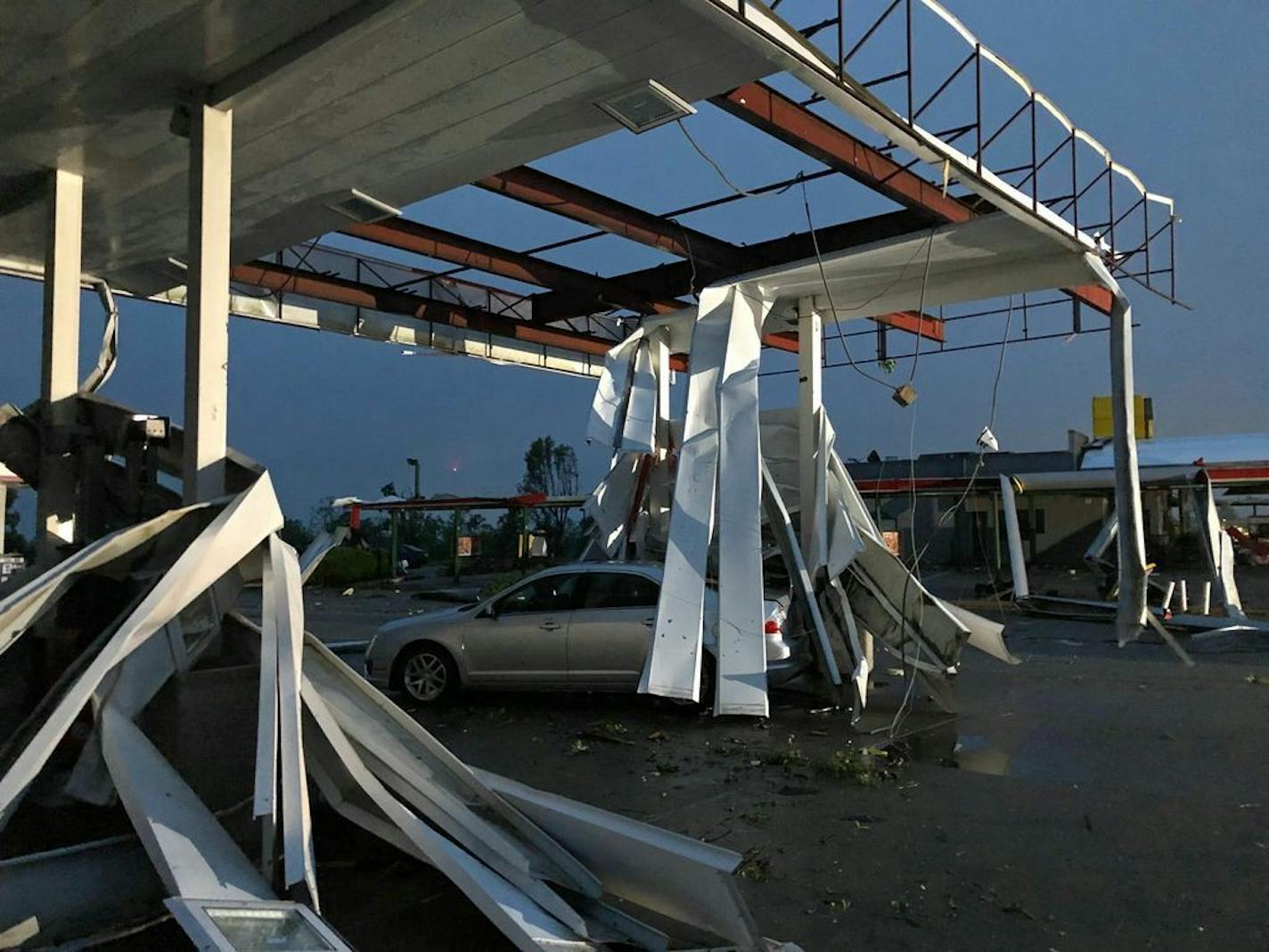 A car is trapped under the fallen metal roof of the Break Time gas station and convenience store in tornado-hit Jefferson City, MO., Thursday, May 23, 2019. The National Weather Service has confirmed a large and destructive tornado has touched down in Missouri's state capital, causing heavy damage and trapping multiple people in the wreckage of their homes.