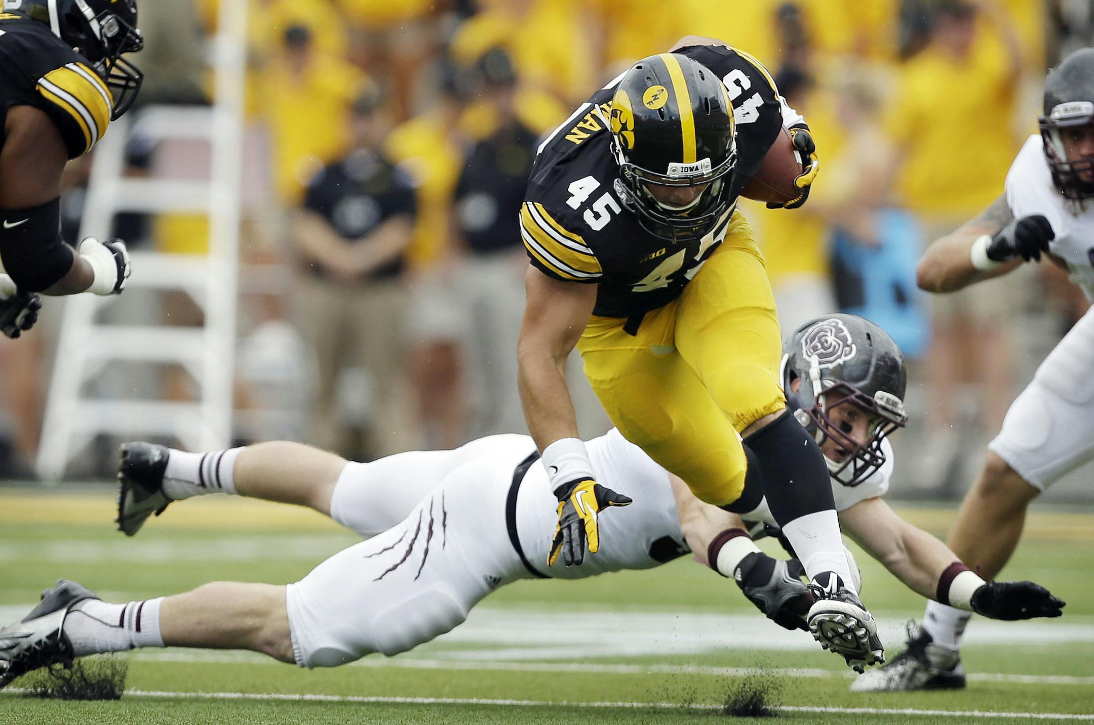 Iowa fullback Mark Weisman (45) breaks a tackle by Missouri State's Tim Piccarreto, rear, during the first half of an NCAA college football game, Saturday, Sept. 7, 2013, in Iowa City, Iowa. Weisman rushed for 180 yards as Iowa won 28-14. (AP Photo/Charlie Neibergall) ORG XMIT: MIN2013092623162552