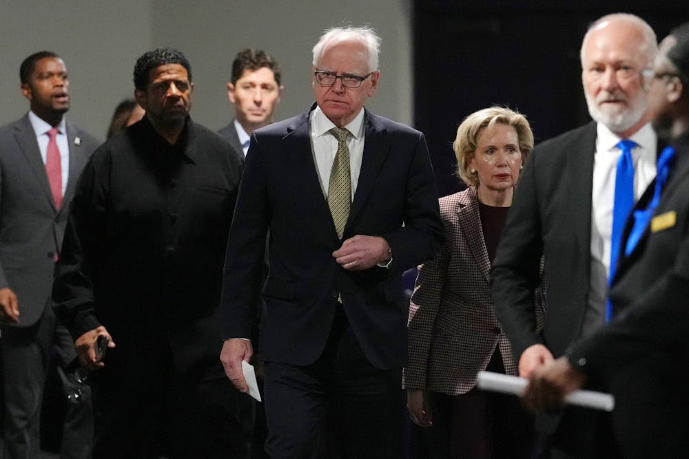Gov. Tim Walz arrives with his wife Gwen for a news conference to address recent federal immigration enforcement efforts in Minnesota amid an increased ICE presence and targeting of U.S. citizens in the state on Dec. 23, 2025. 