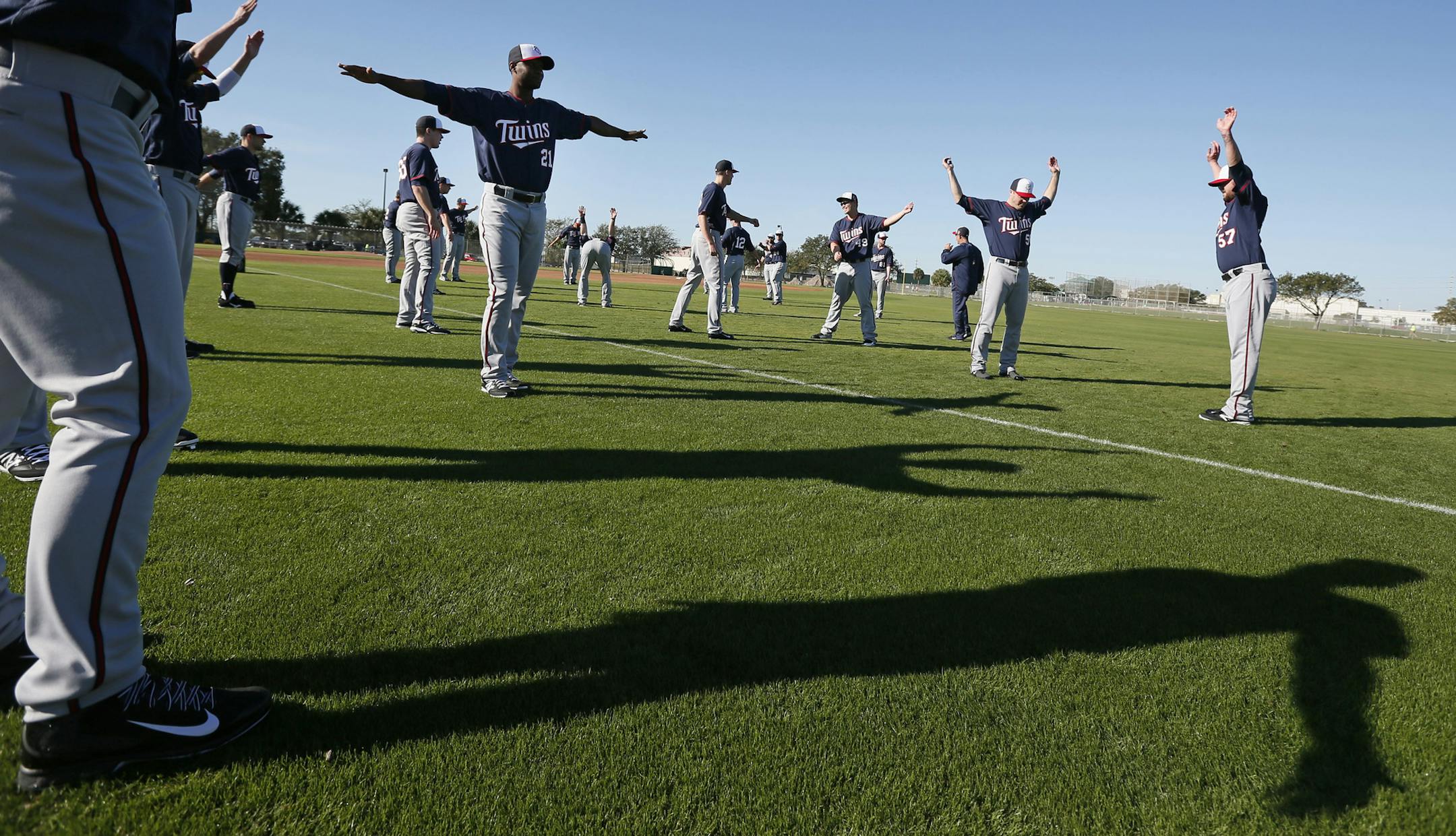 Twins pitchers and catchers warmed up during practice Monday Feb 17. 2014 in Fort Myers, Florida Lee County Sports Complex. Monday is the first full day workout with pitchers and catchers . Pitcher Samuel Duduno is stretching in the center of the photograph.] JERRY HOLT jerry.holt@startribune.com