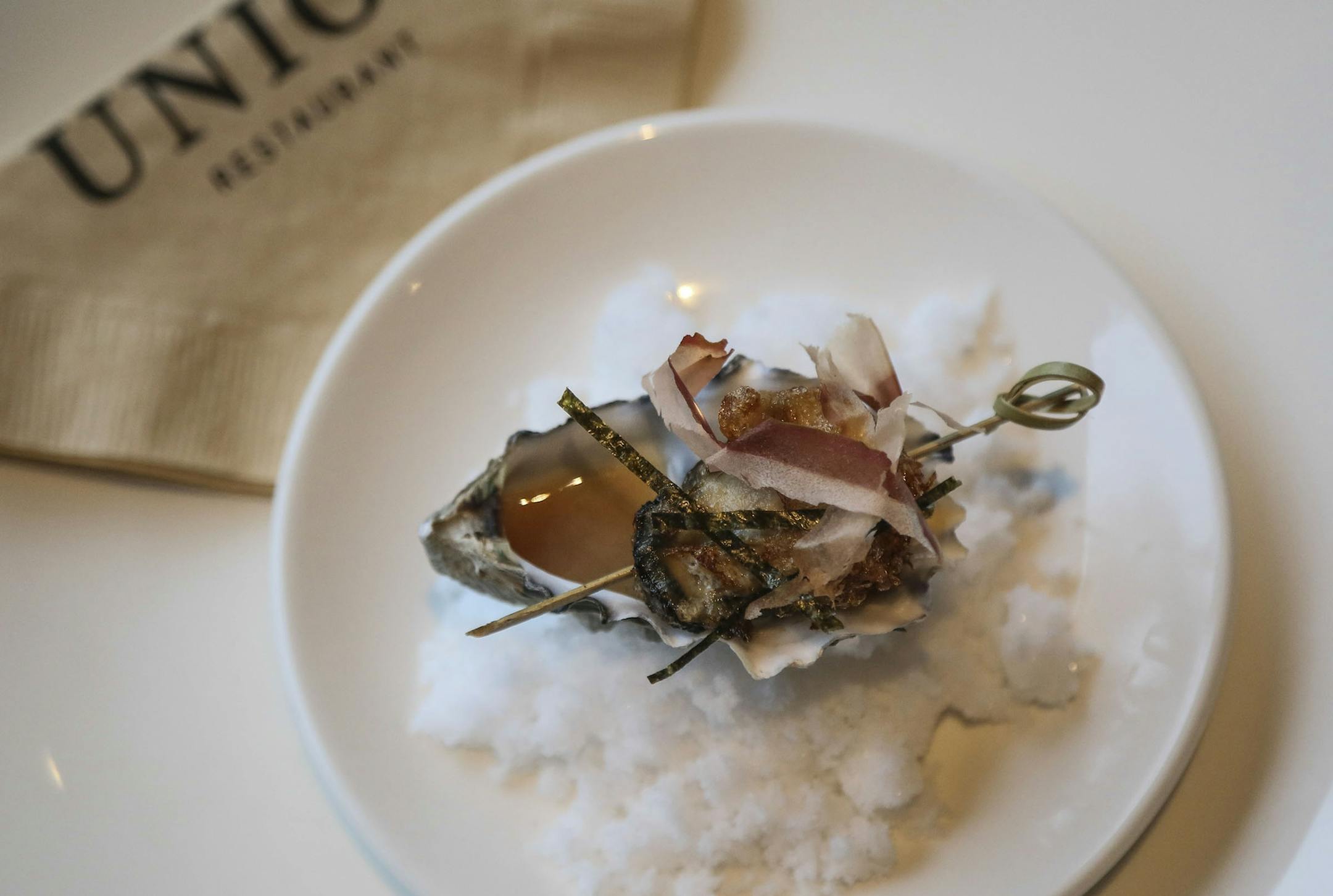 Fried oyster on a half shell on a bed of salt and dashi sauce and shaved bonito at Workshop at Union Friday, Nov. 28, 2014.](DAVID JOLES/STARTRIBUNE)djoles@startribune Workshop at Union guide to new restaurants