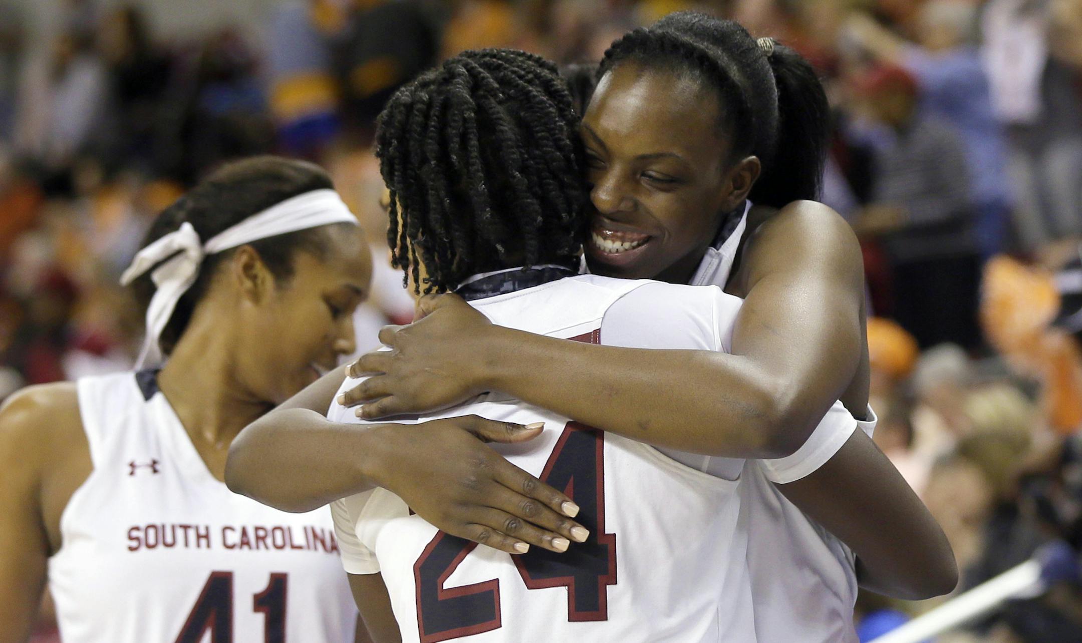 South Carolina's Elem Ibiam, right, hugs teammate Aleighsa Welch (24) in the closing moments of the Southeastern Conference tournament NCAA college basketball championship game against Tennessee in North Little Rock, Ark., Sunday, March 8, 2015. South Carolina defeated Tennessee 62-46. (AP Photo/Danny Johnston)