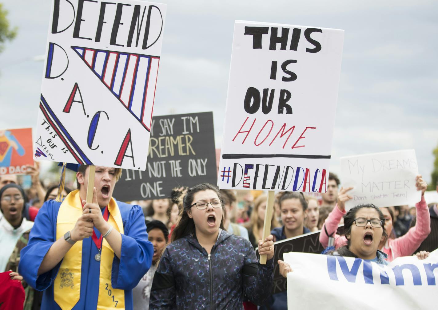 Leading a protest march in Minneapolis over the immigration announcement Tuesday were Daniel Sosa, who wore his graduation robes, and Johanna Evans, a preschool teacher. Both were protected under the Obama program.