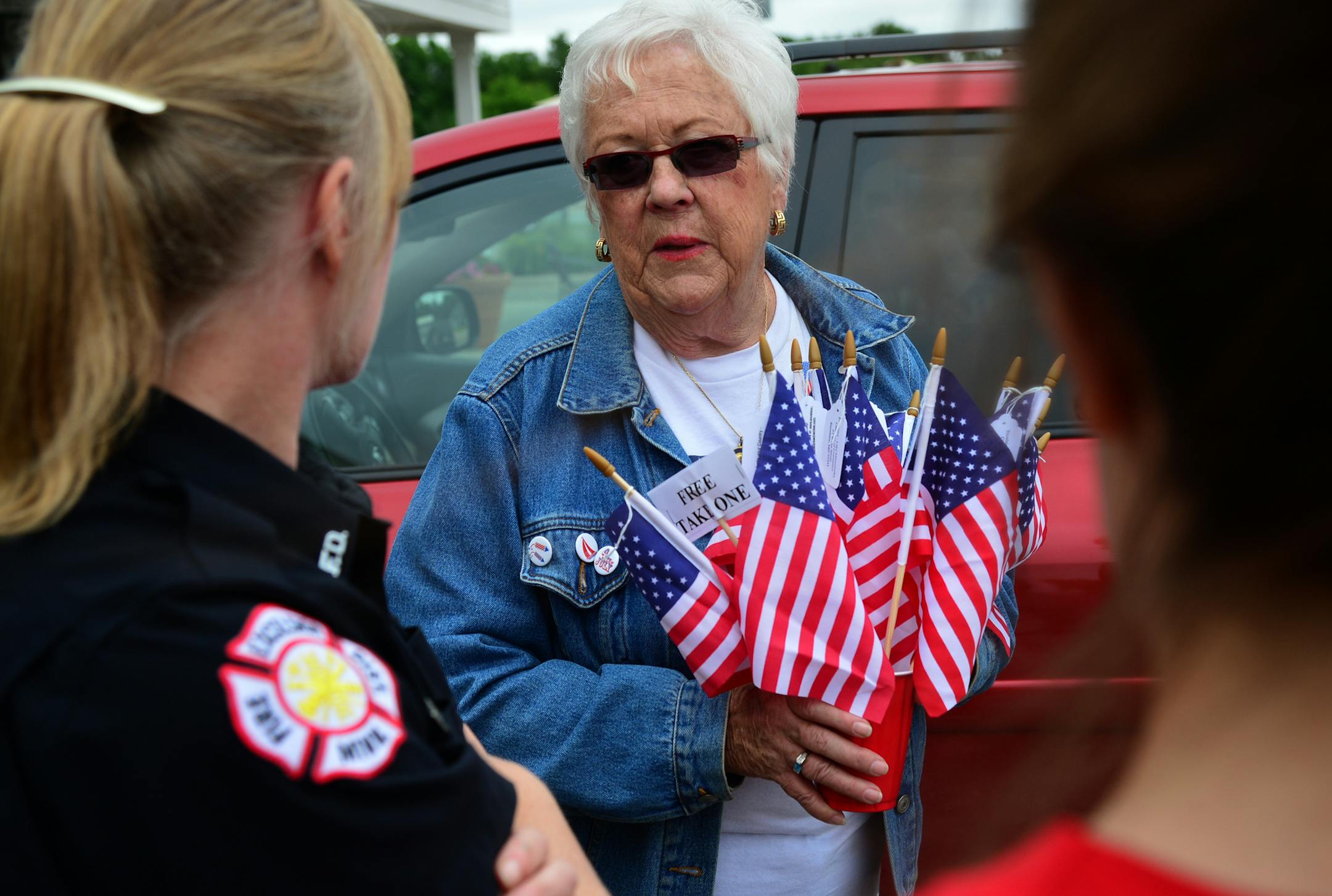 Martie McGlasson of Tonka Bay leaves her house to go door-to-door fundraising for Lake Minnetonka's annual Fourth of July celebration. Carrying a bucket of flags, McGlasson is going around asking residents to help support the largely free event that is mostly supported by donations. When she can't speak directly to residents she will leave a flag with donation information on a tag. ]Richard.Sennott@startribune.com Richard Sennott/Star Tribune Tonka Bay Minn.Wednesday 6/25/2014) ** (cq) ORG XMIT: