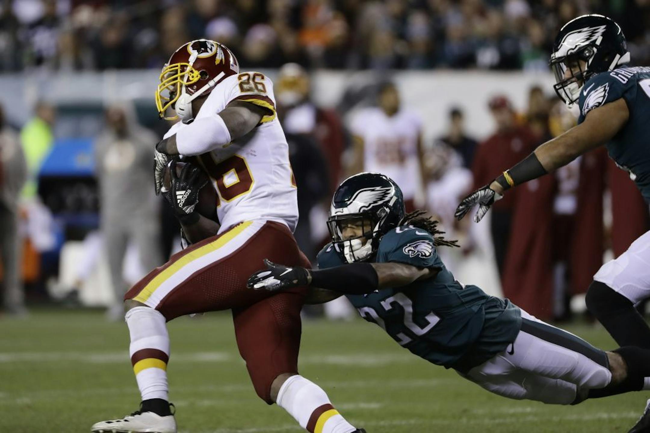 Washington Redskins' Adrian Peterson (26) rushes past Philadelphia Eagles' Sidney Jones (22) for a touchdown during the first half of an NFL football game, Monday, Dec. 3, 2018, in Philadelphia.