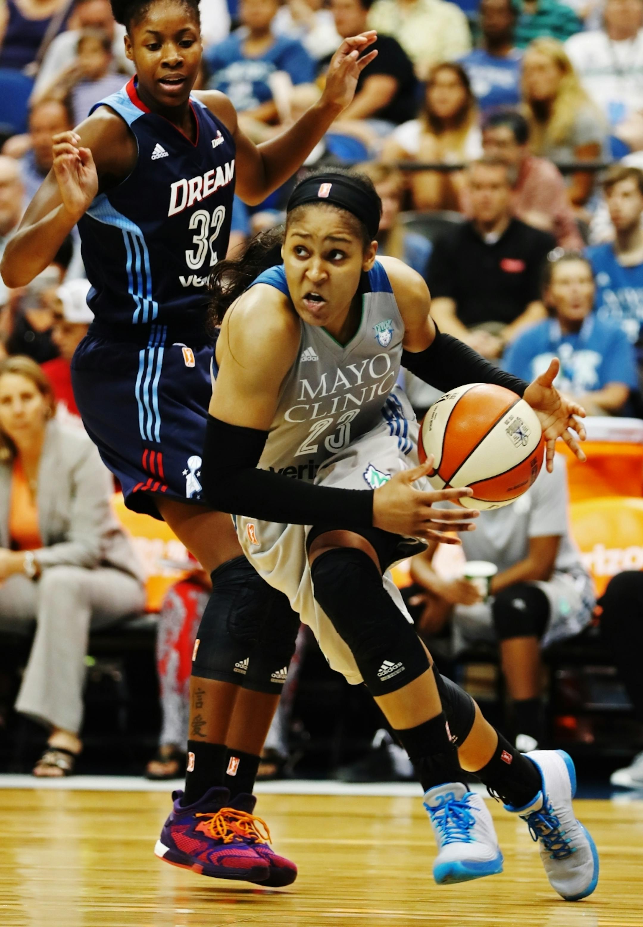 Maya Moore(23) drives by Bria Holmes(32) of the Dream.