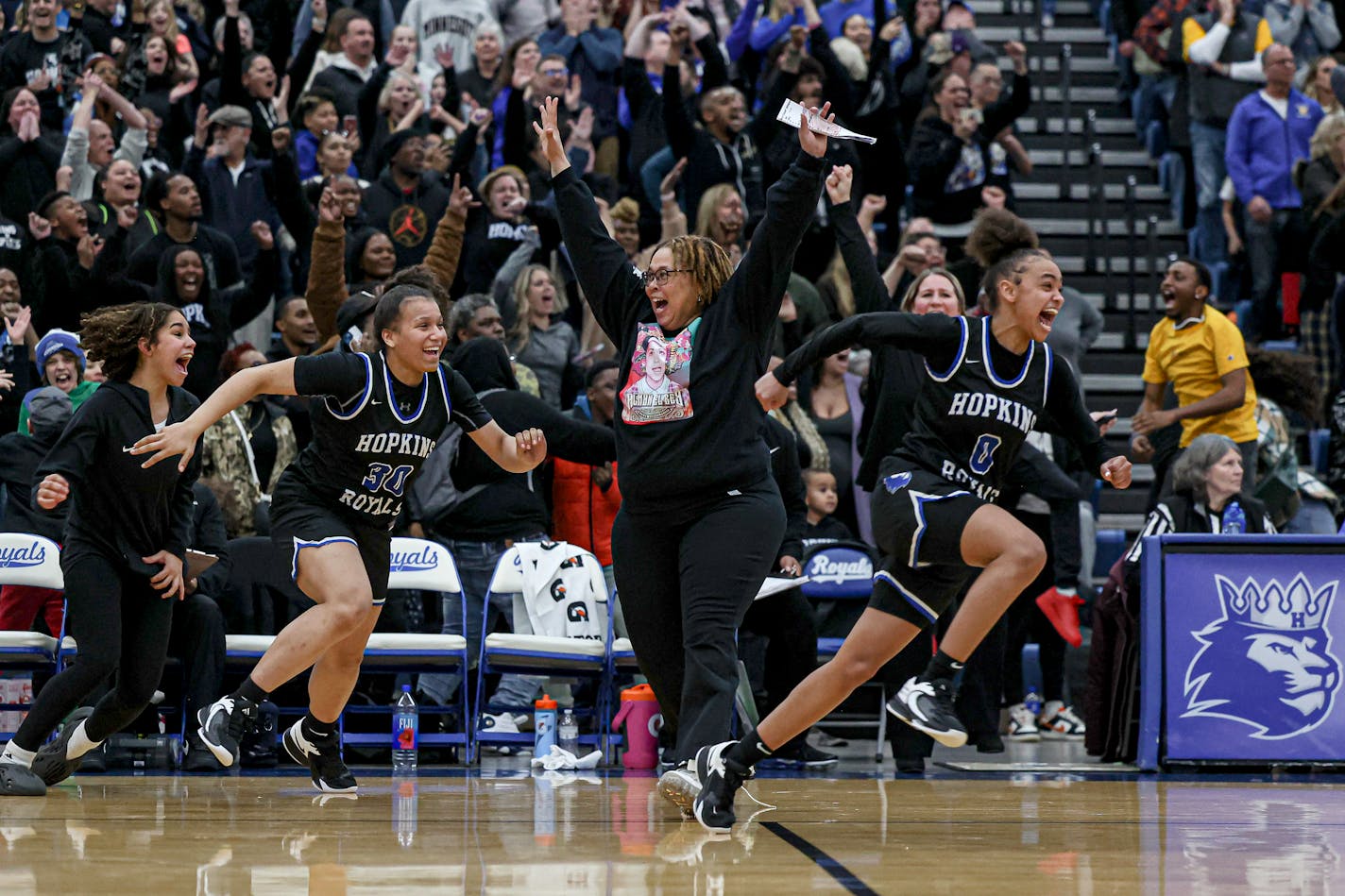 Macaya Copeland (0) and Erma Walker (30) ran to greet teammates as coach Tara Starks celebrated Hopkiins' 70-68 overtime victory over Wayzata. Wayzata vs. Hopkins, girls basketball Section 6 Class 4A championship, 3-9-23. Photo by Mark Hvidsten, SportsEngine