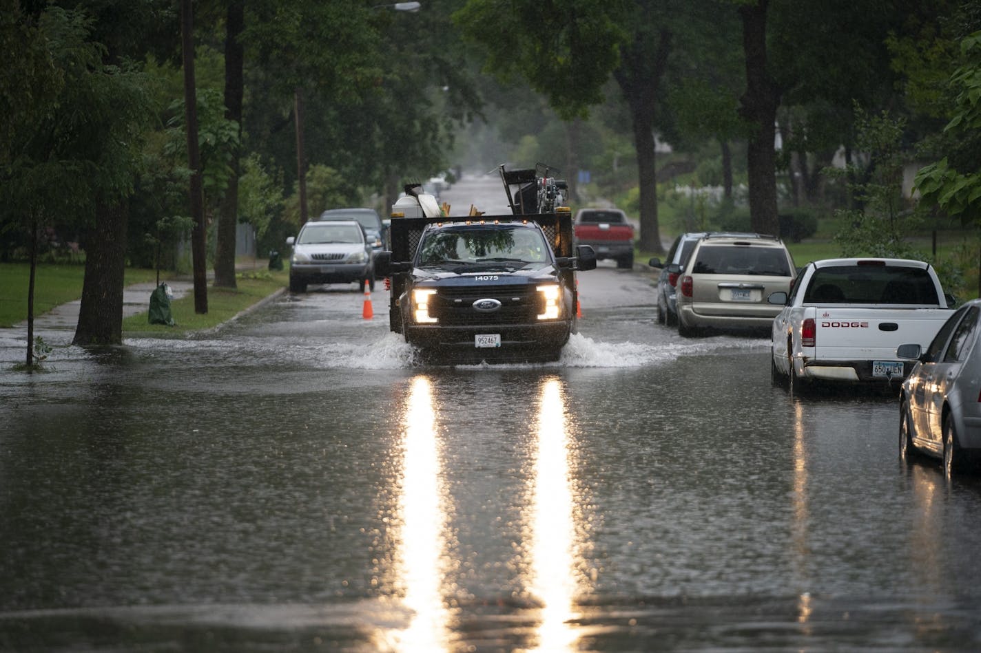 A city of Minneapolis crew drove through standing water while placing traffic cones to warn of the situation on 16th Av. S. at E. 42nd St. Thursday afternoon.