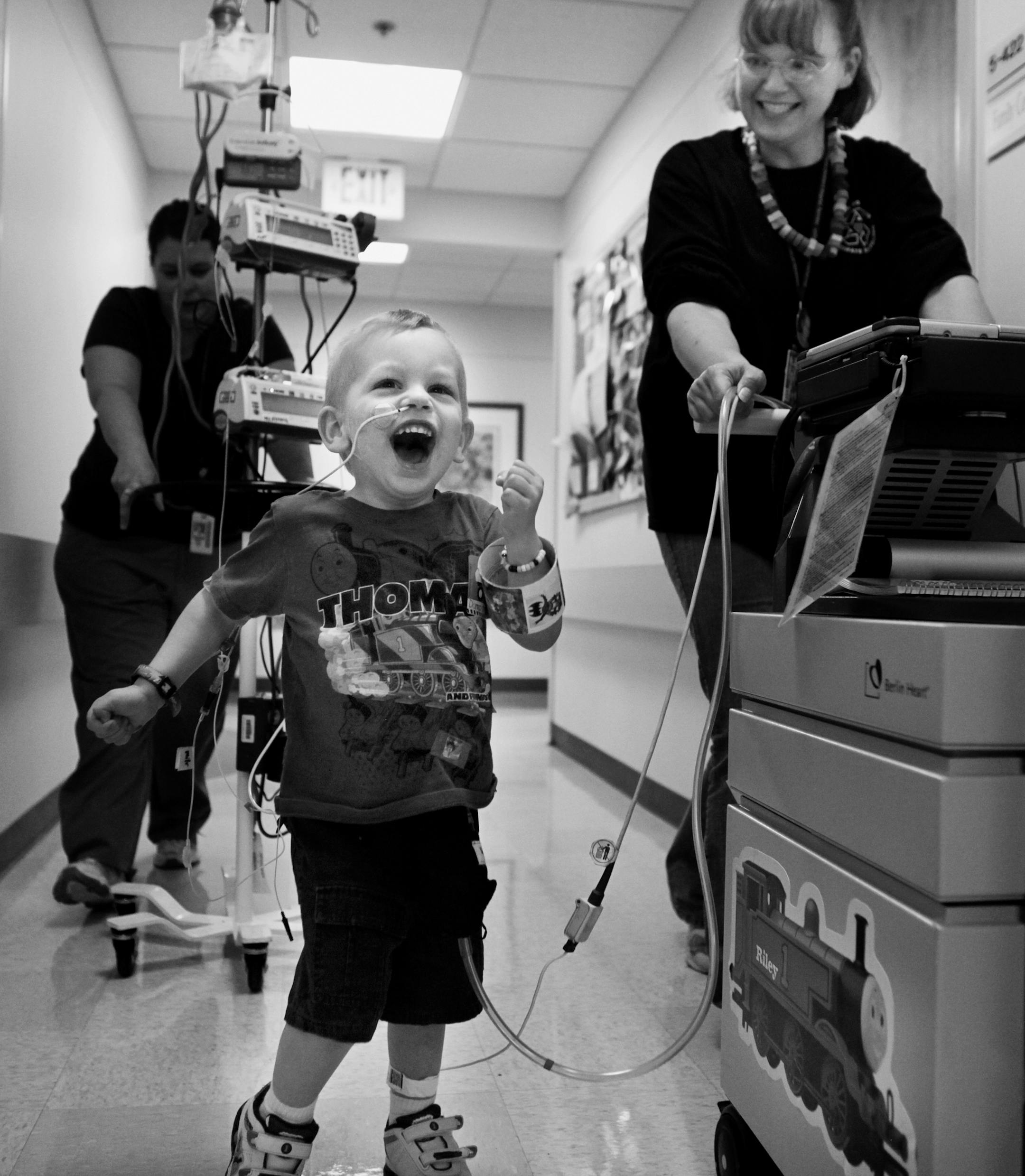 At the intensive care unit of the U of M Amplatz Children's Hospital, Riley Stearns gets his exercise by going around the unit with the Berlin Heart pump assist machine that kept him alive while he waited for a heart transplant. His mother, Peggy pushes the machine with which Riley spent attached to him for nearly a year. Riley died when one of the tubes of his Berlin Heart ruptured. He never left the hospital. At the funeral for her son on March 6, "this is a happy day," said Peggy. Riley was f