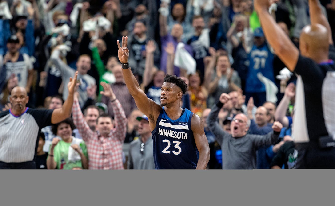 The Timberwolves' Jimmy Butler celebrates with fans after making a three pointer in the fourth quarter of Game 3 at Target Center.