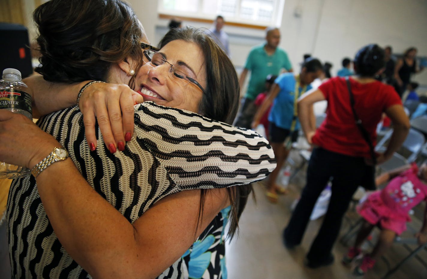 At the new Riverview elementary school, Principal Melisa Rivera got a big hug from St. Paul schools Superintendent Valeria Silva, right. The school is the focus of a new push for neighborhood schools in the city. The hope is that students will stay on the city's West Side instead of going elsewhere.