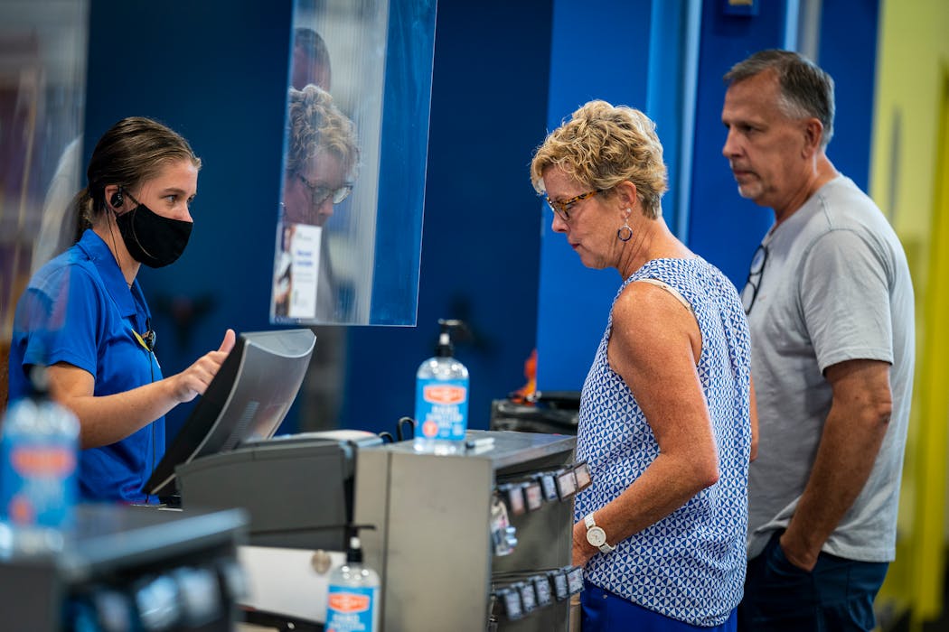 Best Buy employee Lizzie Michalak, from left, helped Cathy and Patrick Peick of Mendota Heights check out in a newly designed customer service, checkout and order pickup area at the Best Buy store in Eagan.
