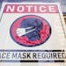 A sign requiring masks as a precaution against the spread of the coronavirus hangs in a store window in Philadelphia on Feb. 16.