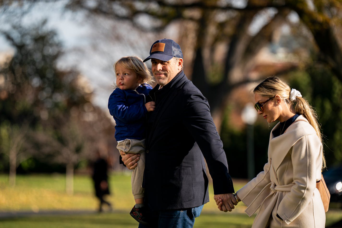 Hunter Biden carries his son, Beau Biden Jr., and holds hands with his wife, Melissa Cohen, as they arrive at the White House Sunday after spending the weekend at Camp David. MUST CREDIT: Photo for The Washington Post by Al Drago.