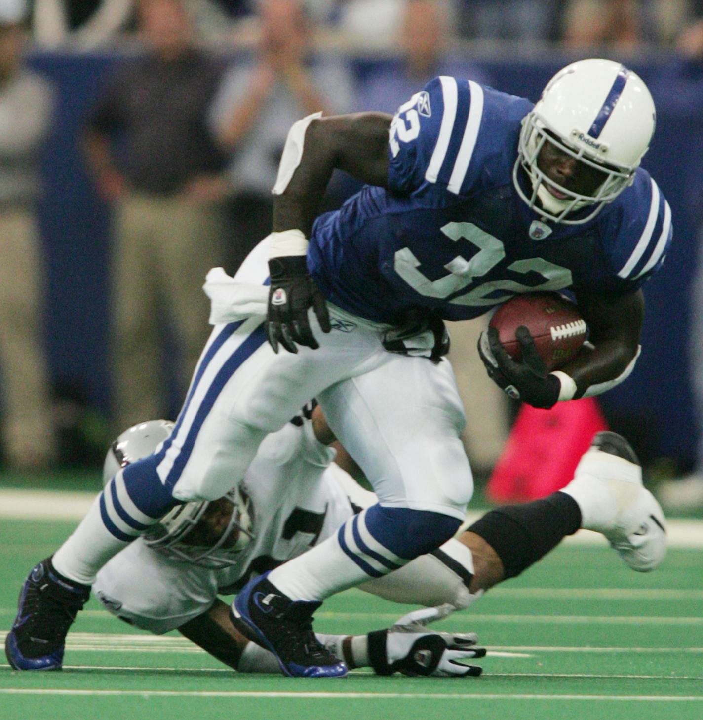 Indianapolis Colts running back Edgerrin James (32) runs out of the tackle of Oakland Raiders cornerback Nnamdi Asomugha in the first quarter in Indianapolis, Sunday, Oct. 10, 2004. (AP Photo/AJ Mast) ORG XMIT: NAD102