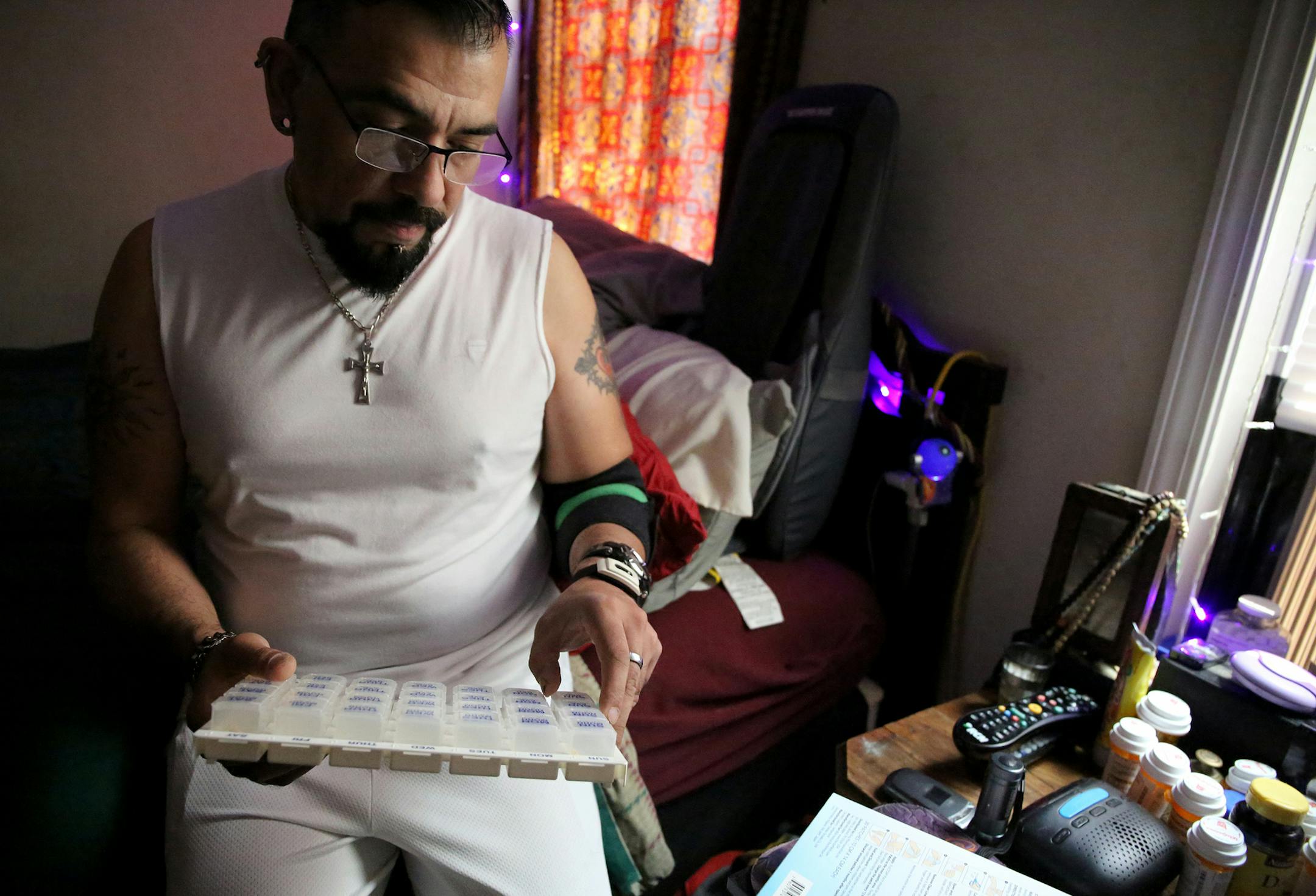 Greg Sanchez, who has been living with HIV for 30 years, displays his many medications stored in the bedroom of his Chicago home on Wednesday, June 3, 2015. Only one pill is for HIV; the rest are for conditions brought on by aging with the virus and years of taking medications to treat it, he says. (Antonio Perez/Chicago Tribune/TNS)