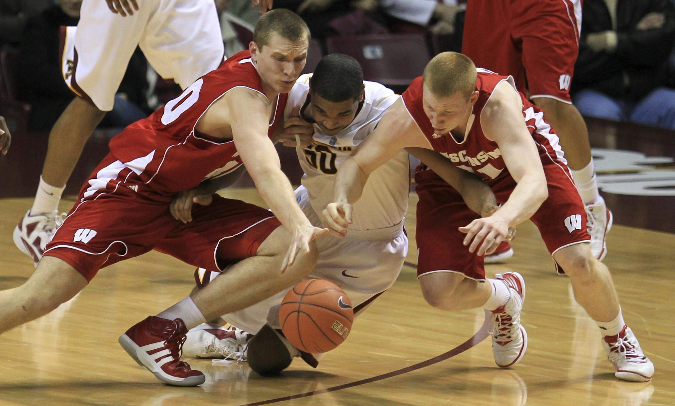 Gophers center Ralph Sampson III was in the middle of a Badger sandwich, between Jared Berggren (left) and Mike Bruesewitz, as the trio scrambled for a loose ball Thursday.
