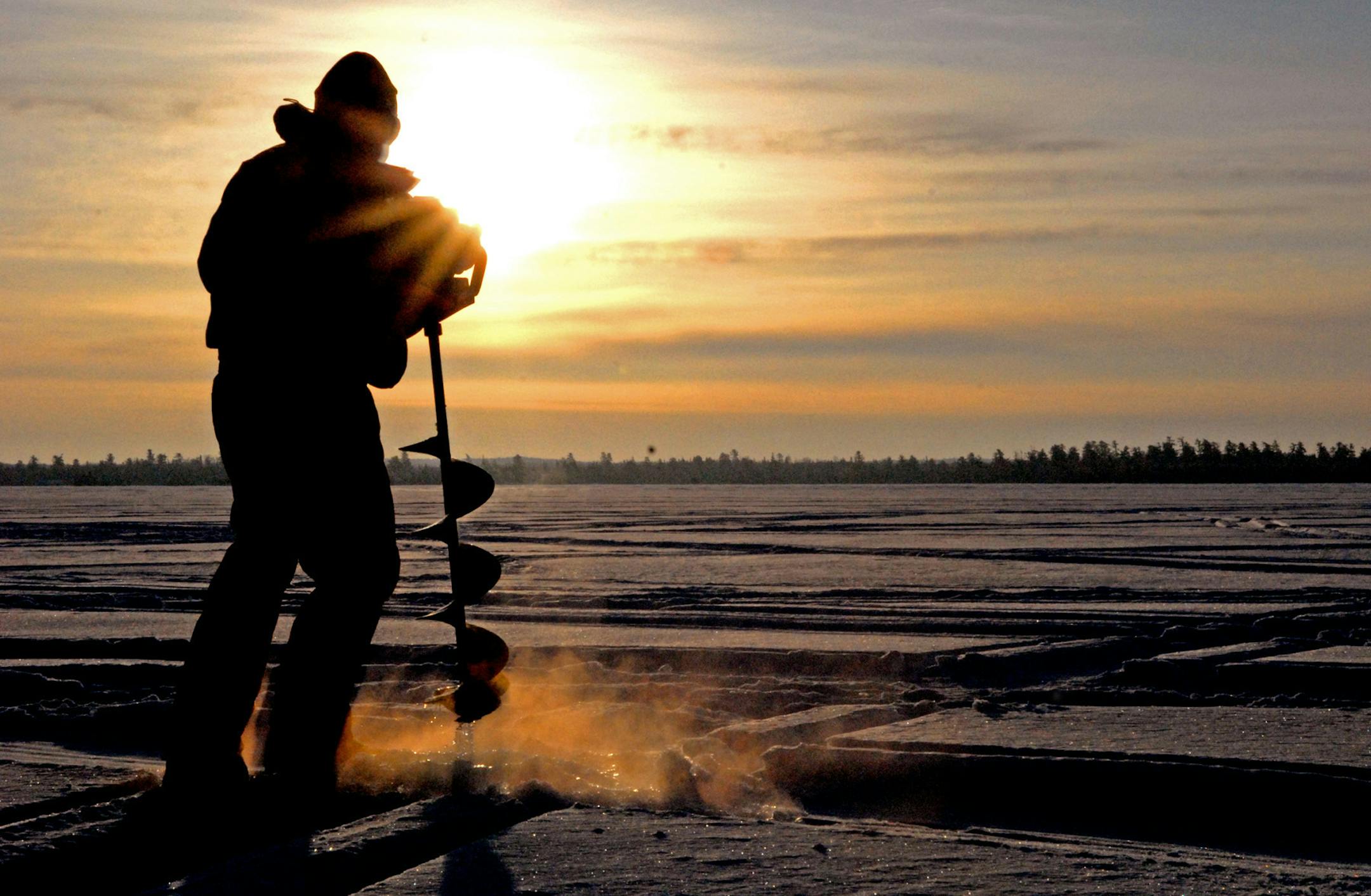 DENNIS ANDERSON ... 1/2009 ... Bill Hanzel augers a hole through the ice of Snowbank Lake, about 18 miles from Ely. Snowbank Lake lies about half inside and half outside the Boundary Waters Canoe Area Wilderness. For the first time in almost 20 years, an ice road has not been plowed for anglers on the lake, due to deep snow and slush. ORG XMIT: MIN2012112715565880