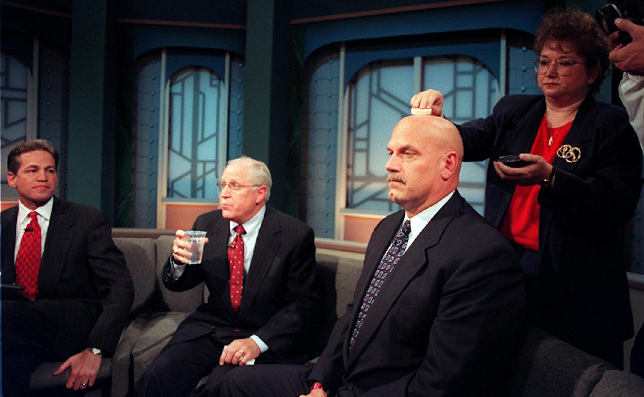 Terry Evans, Senior Administrator for Legal and Content Departments at KTCA TV, right, applies makeup to Reform Party candidate Jesse Ventura's head while Gubernatorial candidates Norm Coleman, Hubert Humphrey III, prepared for their last debate at KTCA in St. Paul on Friday night.